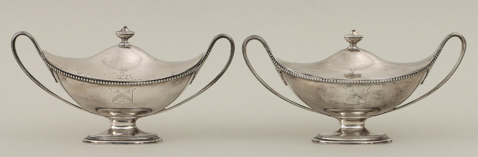 Pair of George III sterling silver covered dishes: Pair of George III sterling silver covered dishes with beaded decoration, lids having urn-form finial and stag engraving, bodies having handles ending in acanthus leaves and engraved coat of arms with