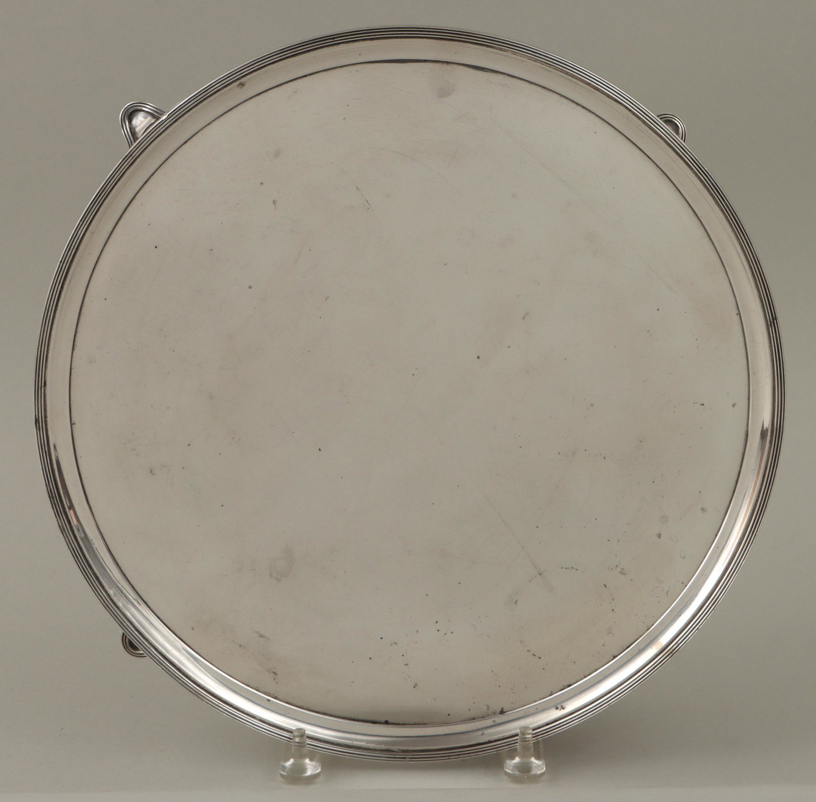 George III sterling silver footed salver: George III sterling silver footed salver, Henry Chawner, London, 1791, with reeded border, hallmarked on bottom. Split, repairs, scratches, minor dents. 1-3/4''h, 13-13/16''dia; approximate weight 36.