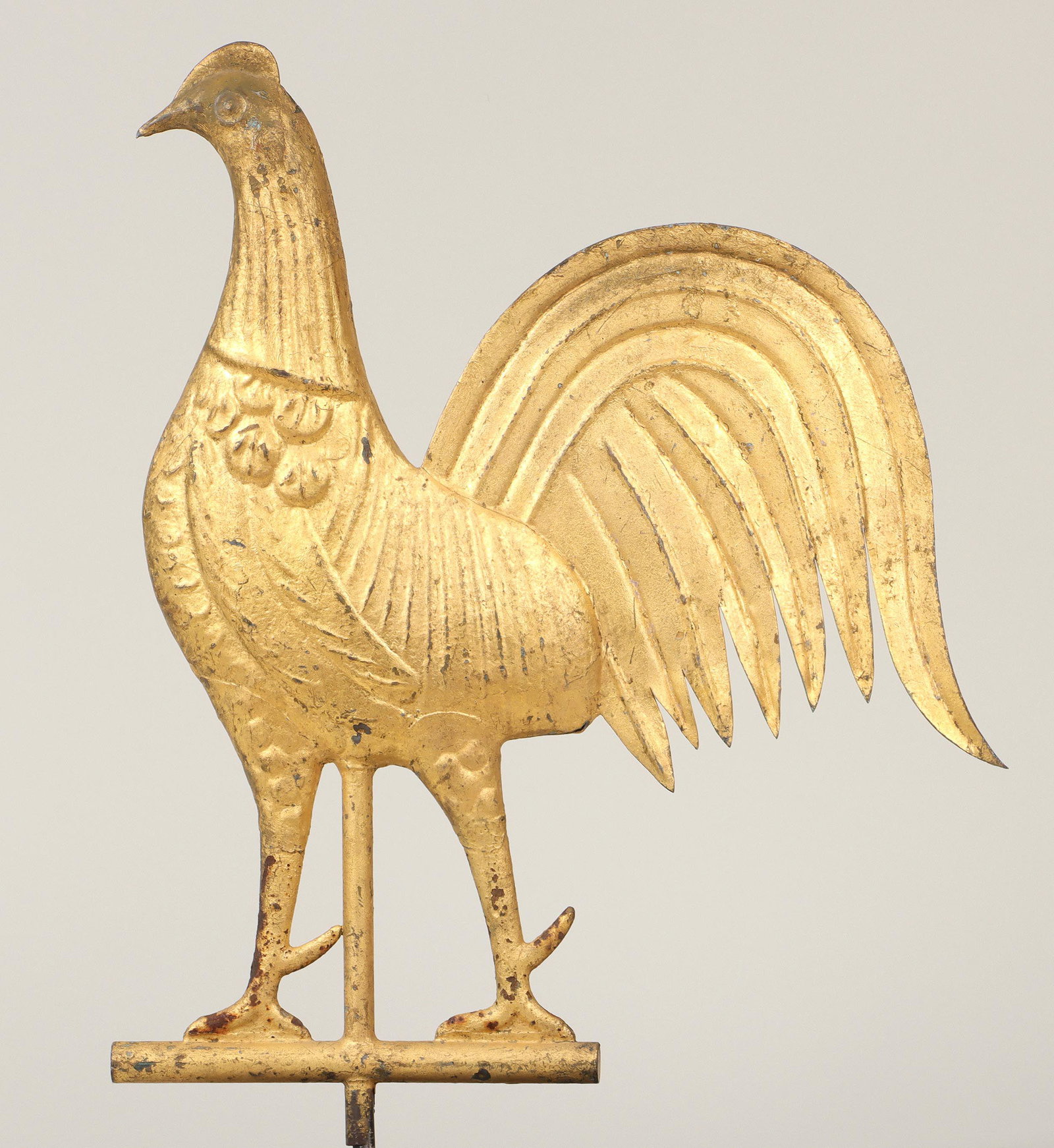 American gamecock weathervane: American folk art full-bodied molded copper gamecock weathervane, having cast iron feet and flat copper tail feather, gold painted. Rust to feet, some paint loss. 14''h, 1-1/2''w, 18''l. Provenance: E