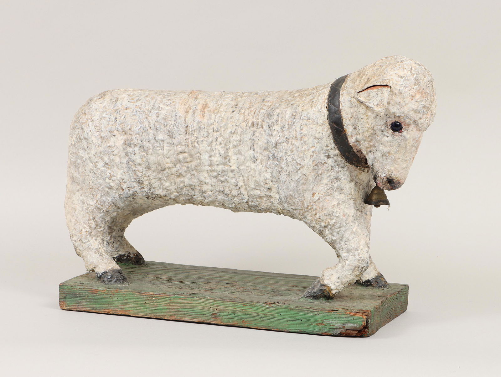 Folk art papier mache lamb: Folk art polychrome-painted papier mache lamb, with bell around neck and blue glass eyes, on green-painted wood base, signed ''Gould Anderson'' on bottom. Minor losses, splits and wear. 15''h, 21''w,