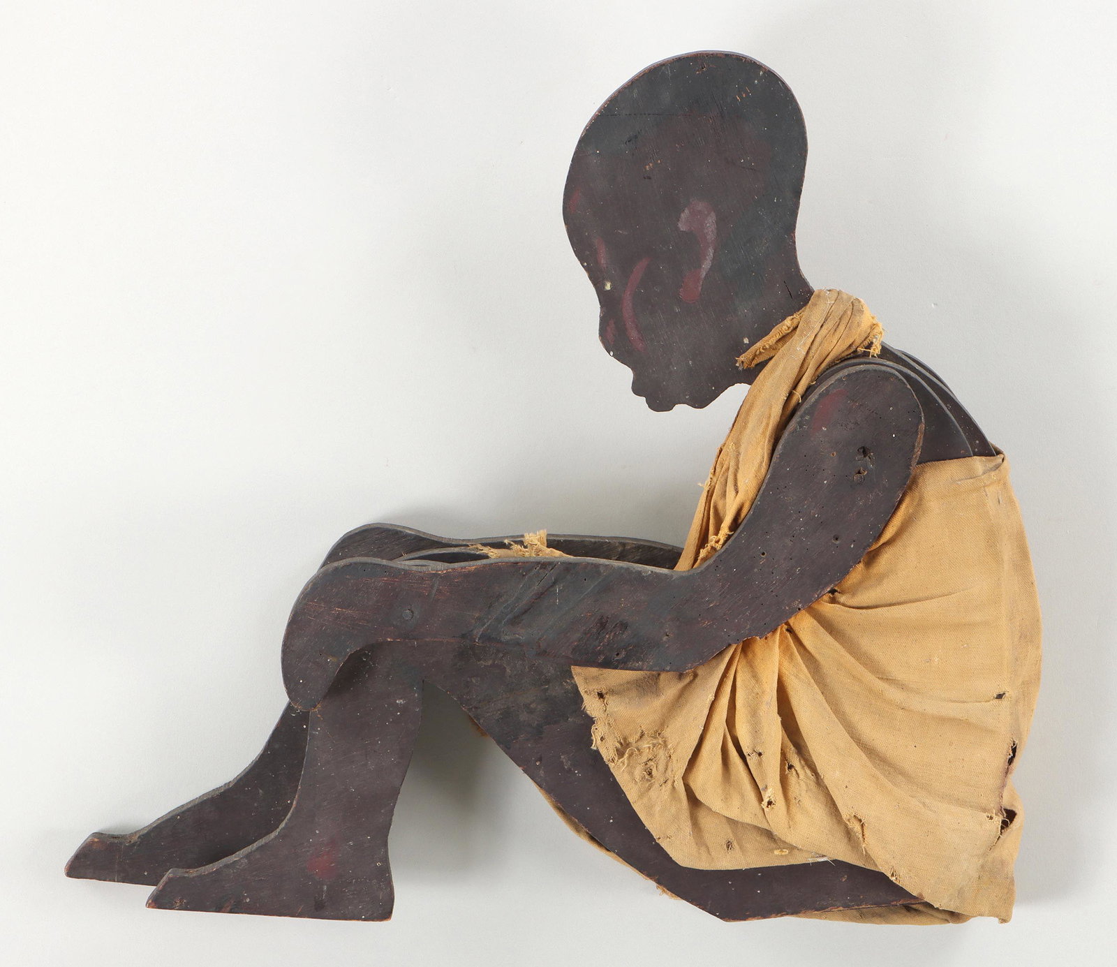 Black Americana folk art figure of child: Black Americana folk art figure of child, sawn and painted wood with cotton clothing, early 20th century. 17-1/2''h, 18-1/4''w, 4''d. Provenance: Estate of Joseph ''Jay'' St. Mark, PhD, of Newtown, Co