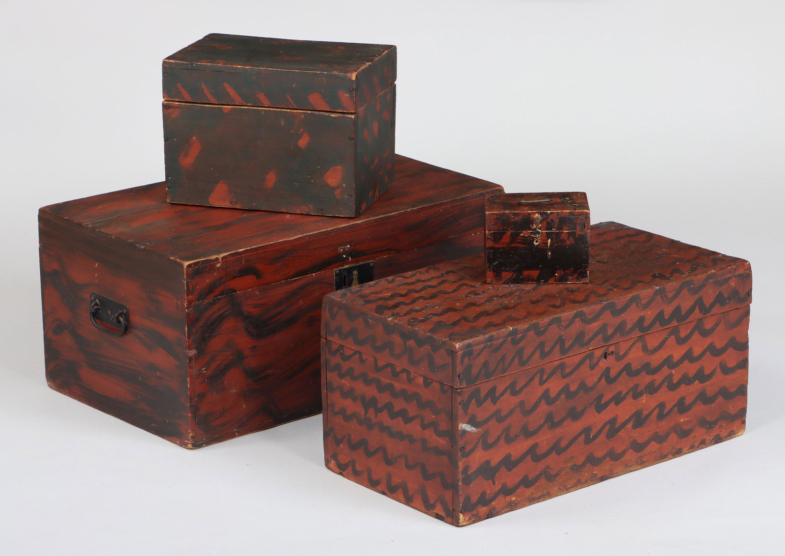Group of (4) grain paint decorated wood boxes: Group of (4) grain paint decorated wood boxes, two with iron carrying handles, one with latch. Minor scratches, wear and paint losses; latch replaced; one box with splits. Largest box 11-1/4''h, 24''w