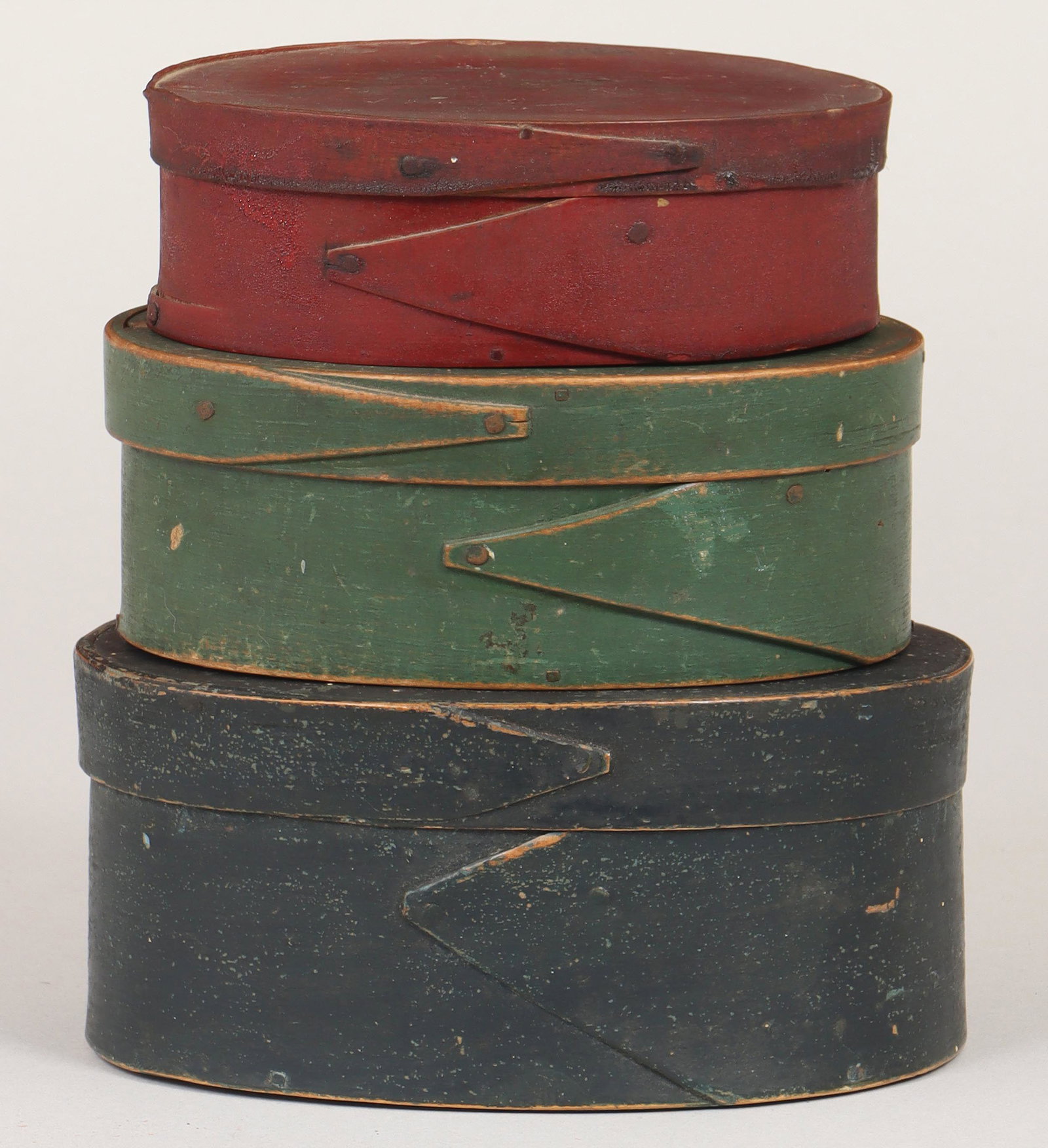 Group of (3) painted oval pantry boxes: Group of (3) painted oval pantry boxes, with finger laps, to include: red box, with stencil fruit bowl still life to top, (repaired); green box; and blue box, marked ''H'' on top (lid stuck on). Minor