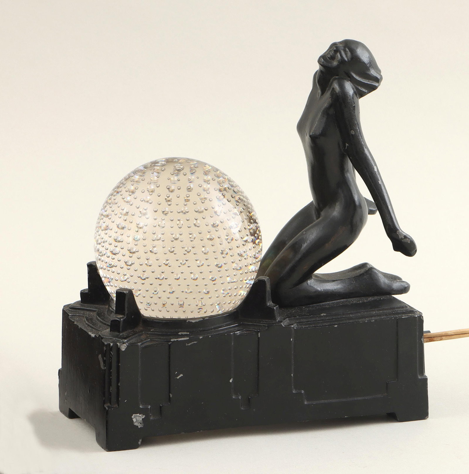 Frankart Art Deco figural lamp: Frankart Art Deco figural lamp, having black-painted rectangular base with nude female figure kneeling before a glass sphere with controlled bubbles, embossed ''Frankart Inc'' on one end of base. Pain