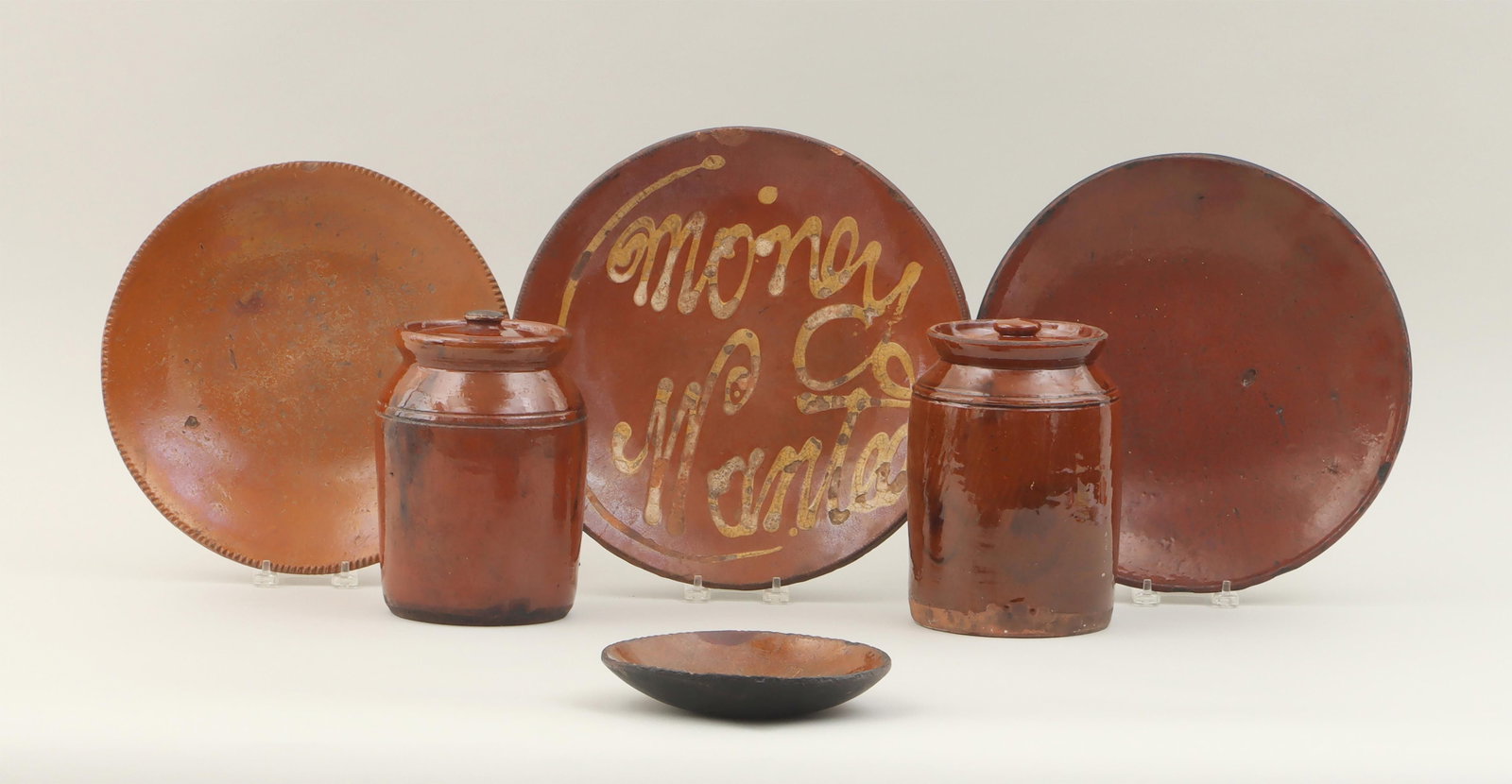 Group of (6) redware table articles: Group of (6) redware table articles, to include: (2) covered jars, (one lid with chips, one jar with firing cracks); small plate with coggled rim and black-painted underside, (repairs at rim); large p