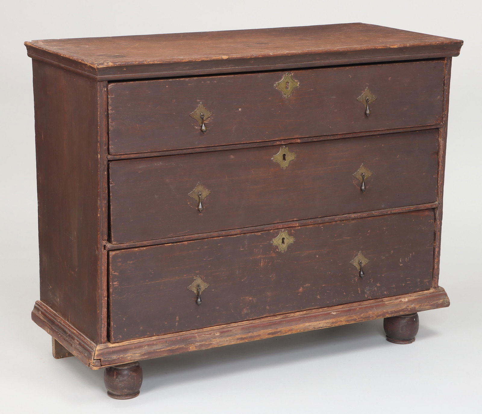 William and Mary painted American chest: William and Mary painted American three-drawer chest with drop pulls, on ball front feet and stile back feet, in brown paint. Well worn, repairs, later repaint. 30-3/4''h, 39-1/4''w, 16-1/2''d. Proven