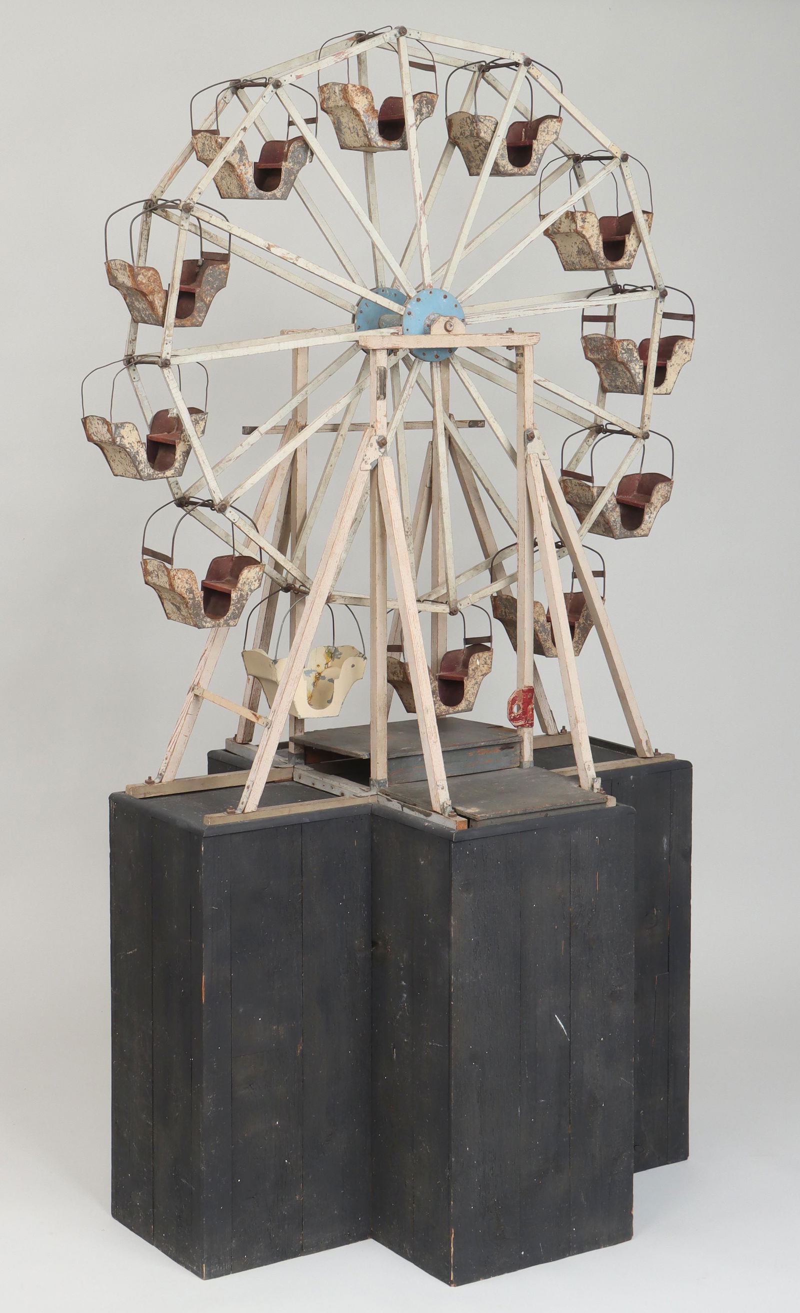 Large folk art Ferris wheel model: Large folk art Ferris wheel model, painted wood and sheet metal, first half 20th century, possibly for store window display; set on a later fitted pedestal. Dirt and grime, paint loss, one carriage re