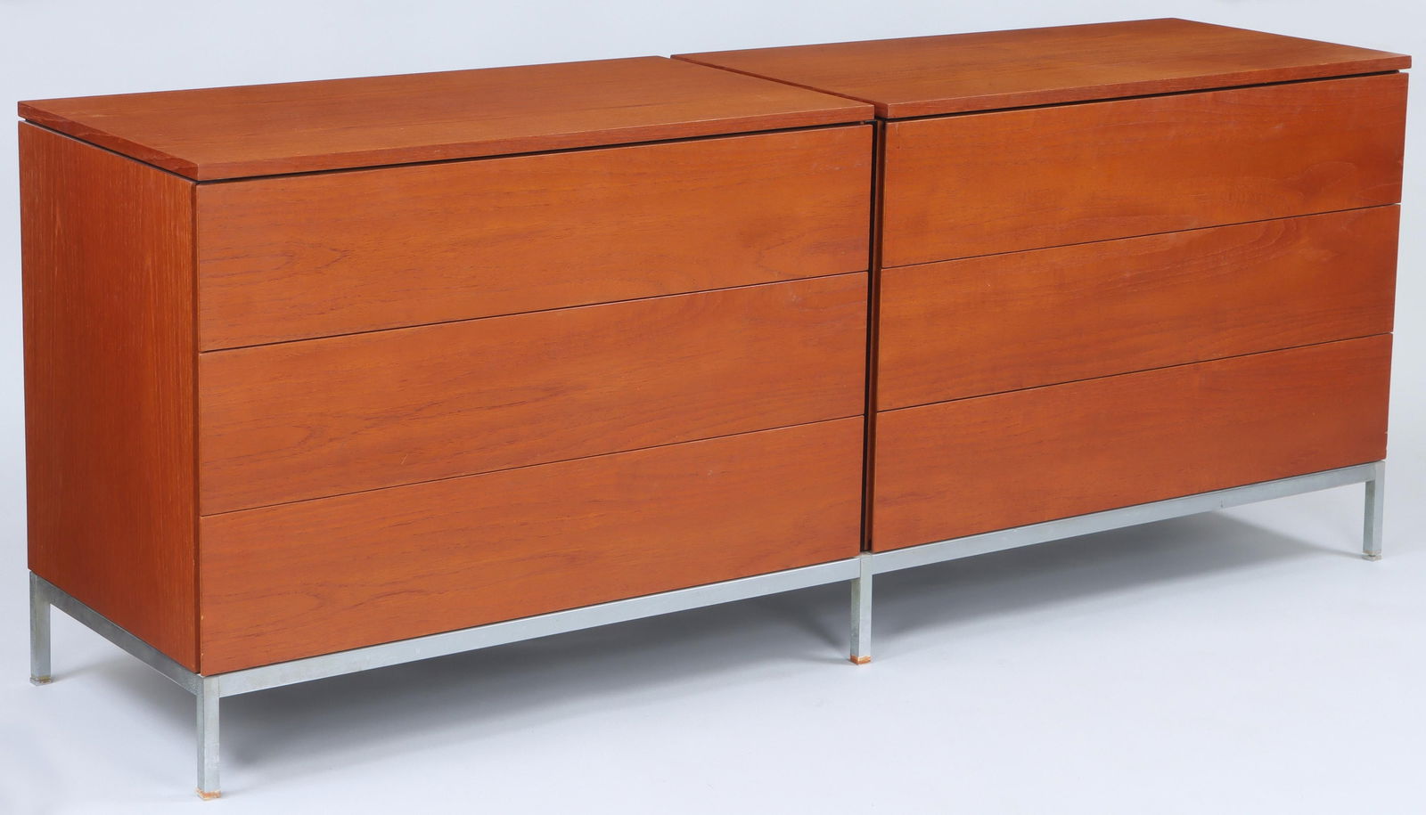 FLORENCE KNOLL (American, 1917-2019): FLORENCE KNOLL (American, 1917-2019), Knoll International, double chest of drawers, having two adjoined teak veneered three drawer chests, top drawers with sliding tray, set on chrome base with adjust