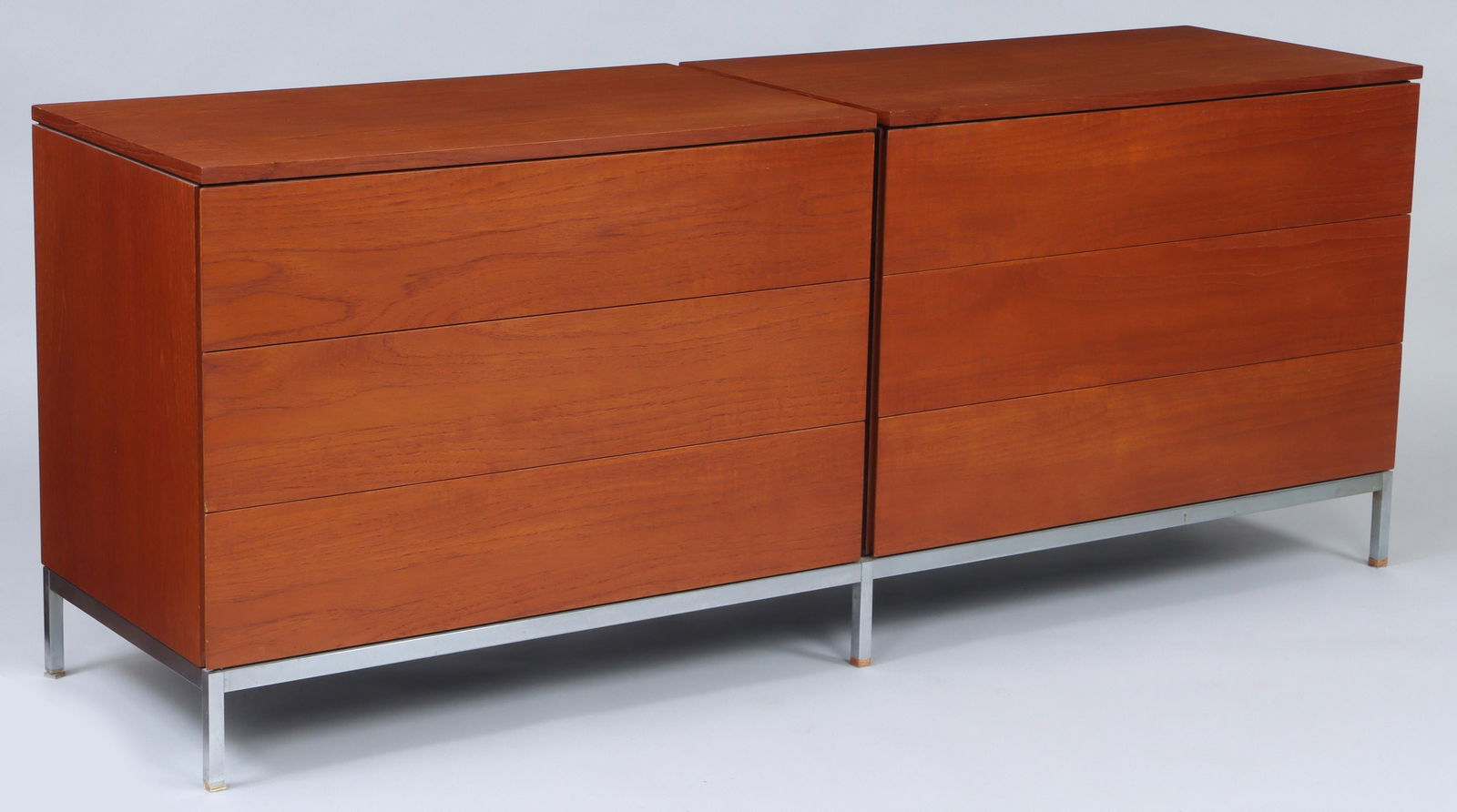 FLORENCE KNOLL (American, 1917-2019): FLORENCE KNOLL (American, 1917-2019), Knoll International, double chest of drawers, having two adjoined teak veneered three drawer chests, top drawer with sliding tray, set on chrome base with adjusta