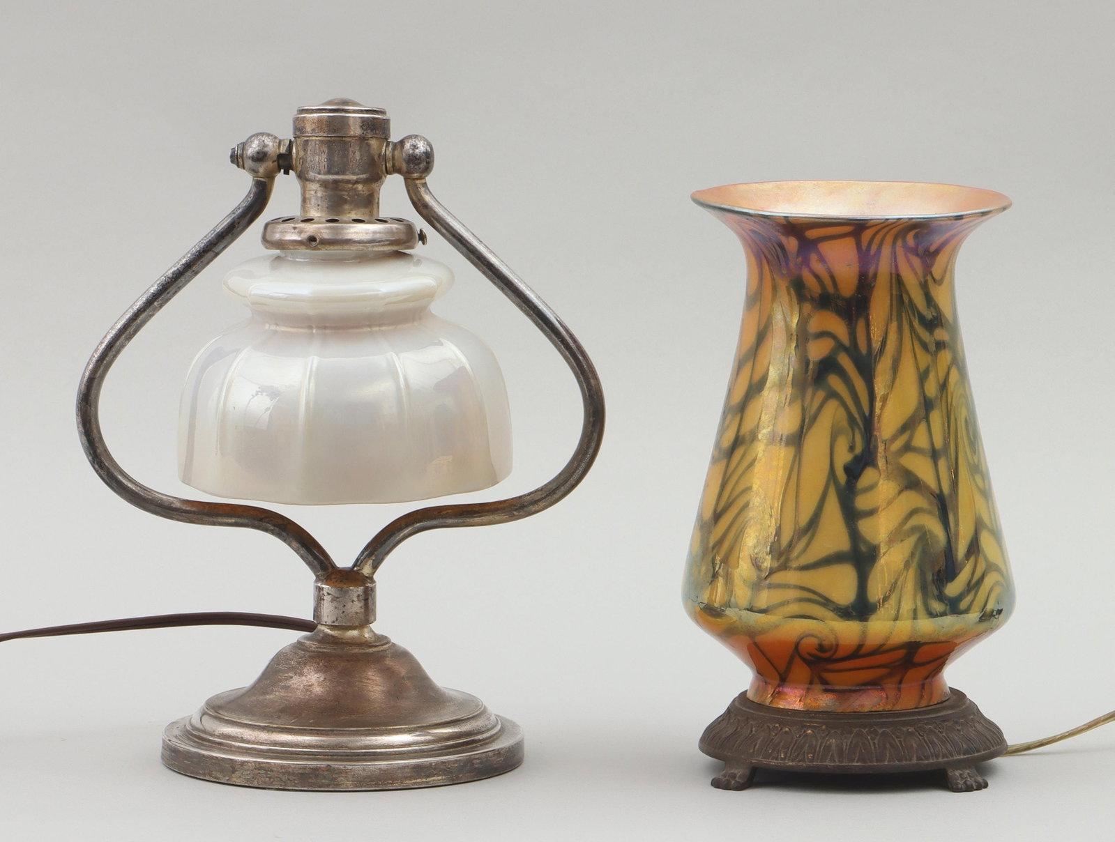Group of (2) lamps with iridescent art glass shades: Group of (2) table lamps with iridescent art glass shades, to include: silver-plated harp table lamp having ribbed art glass shade with pearlescent white exterior and iridescent gold interior, socket 