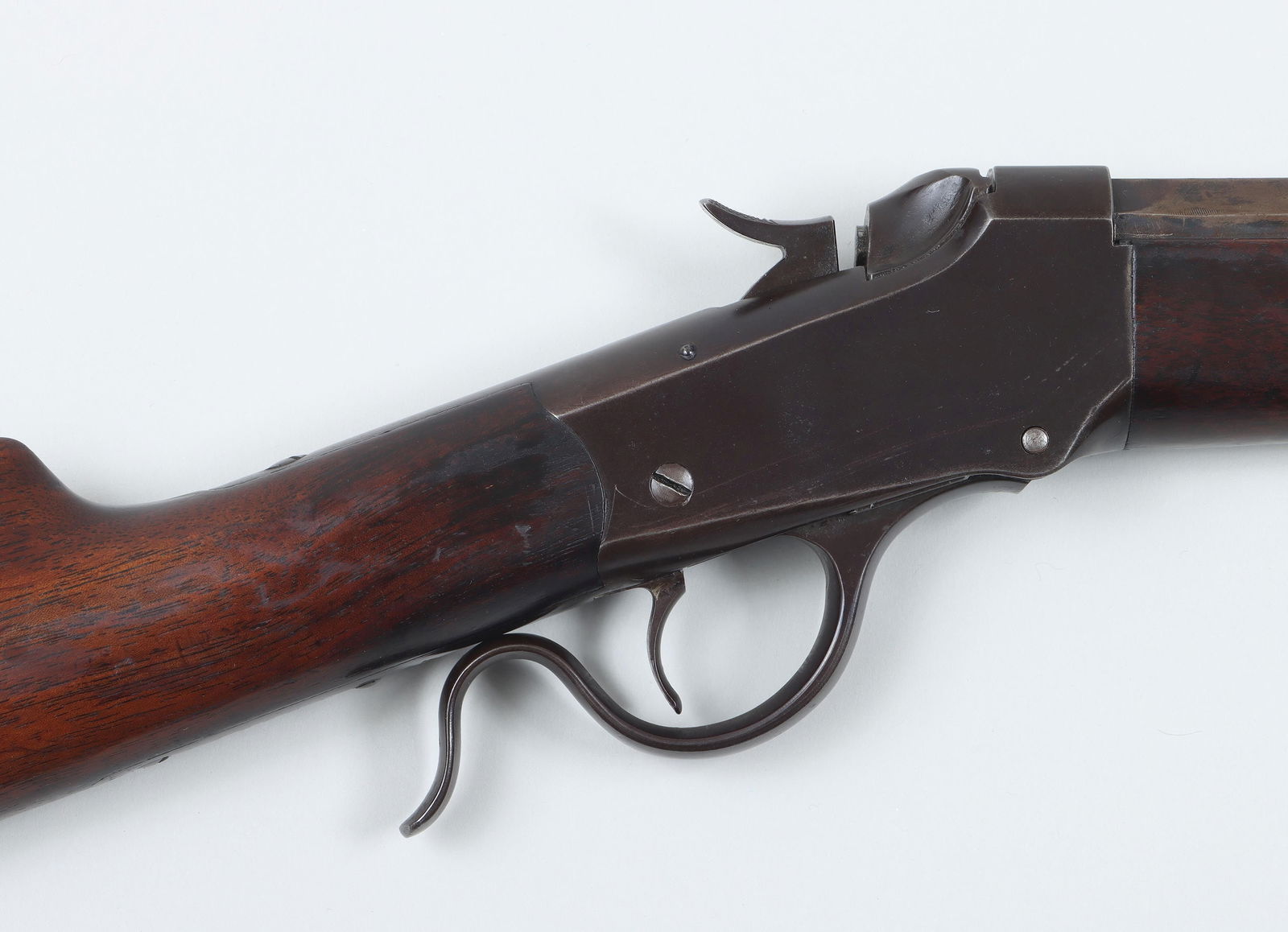 Winchester low wall single-shot rifle: Winchester low wall single-shot rifle in 25 RF. The octagon barrel measures 26'' with a fair bore and standard open sights. The receiver and metal parts are blued, with some wear to the barrel and are