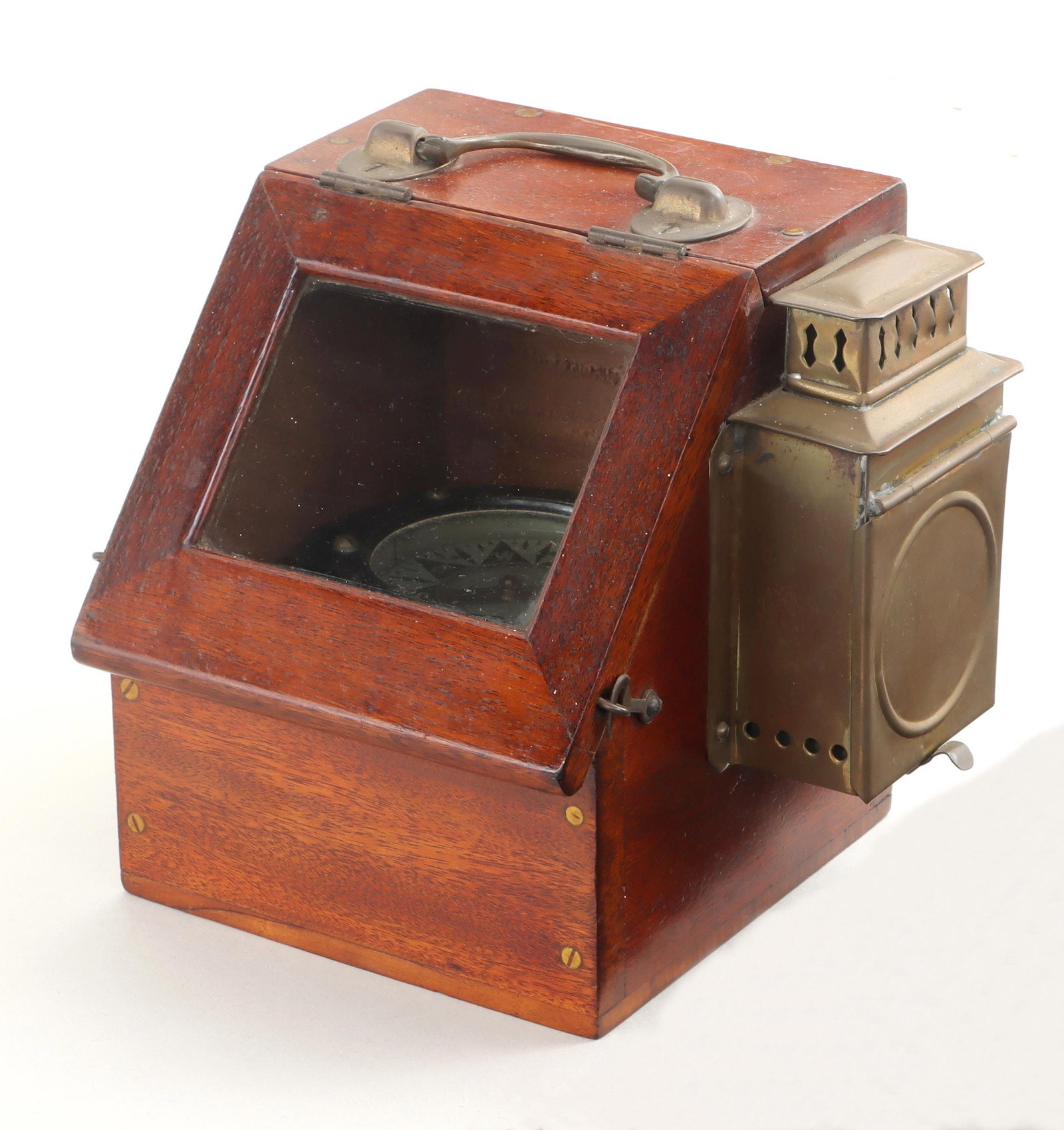 Small yacht compass: Small yacht compass in mahogany case, having articulated handle, hinged door with glass window, and pierced brass case on side with removable lantern, unmarked. Wear, minor dirt and grime. Repairs to 