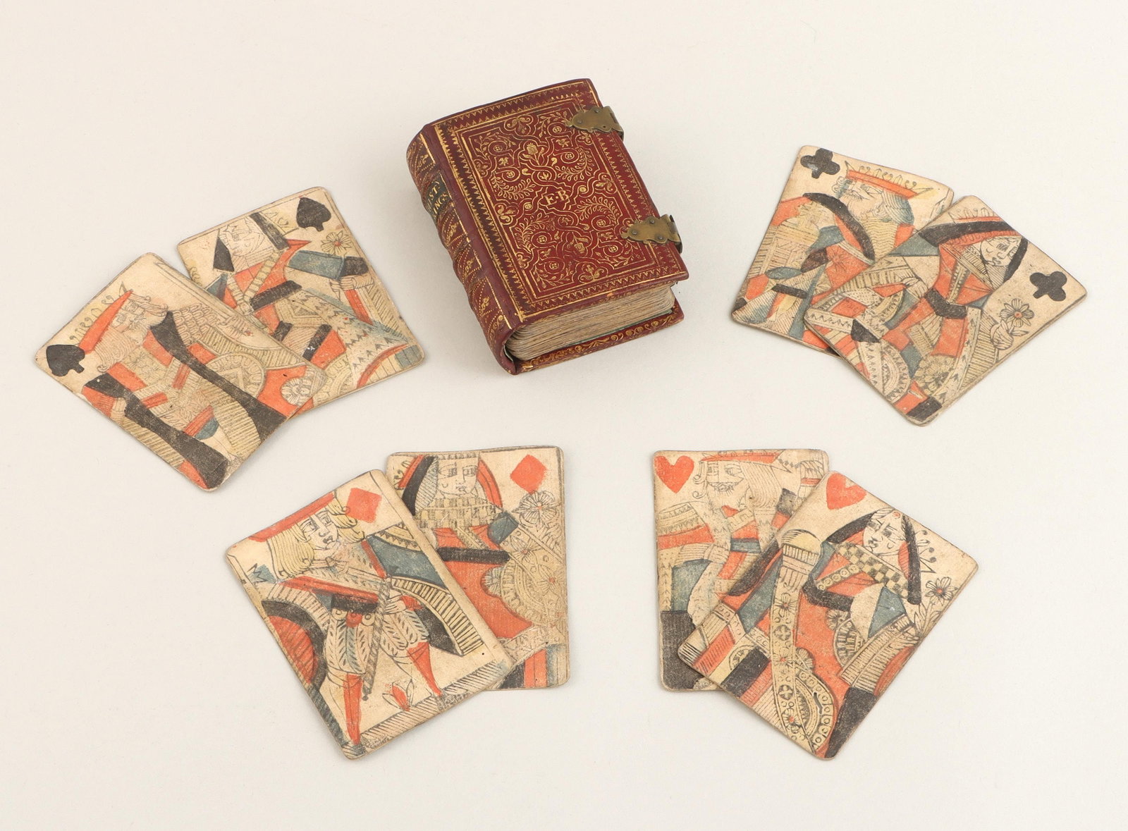 Early 18C English playing card pack: Early 18th century English playing card pack of 52, housed in gilt tooled red Morocco leather English ''fanfare'' binding with brass clasps, and black morocco label bearing title ''The Hist. of 4 King