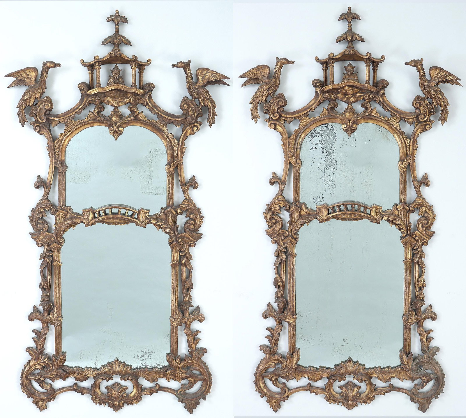 Pair of Chinese Chippendale-style mirrors: Pair of Chinese Chippendale-style carved giltwood mirrors, having a pagoda crest with figural bust, flanked by Ho Ho birds, above a central bridge surrounded by foliate scrolls, 19th/20th century. Sev