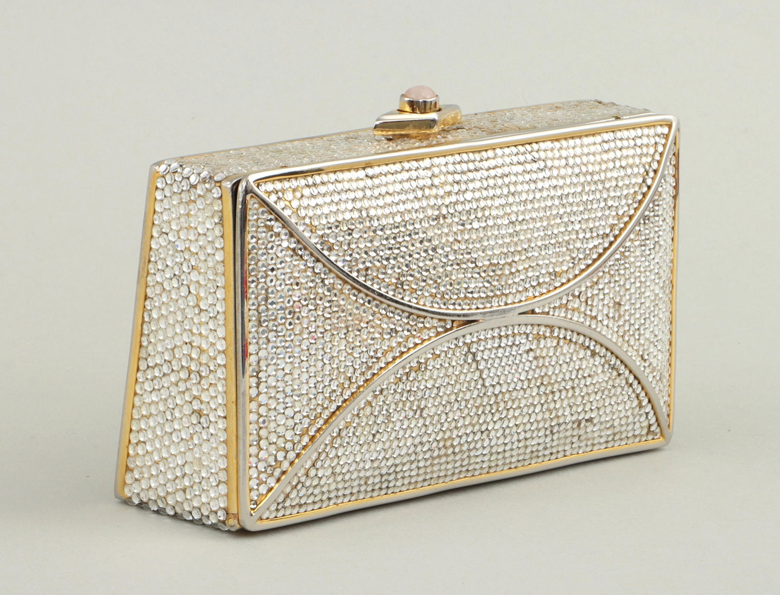 JUDITH LEIBER: JUDITH LEIBER (Hungarian-American, 1921-2018), minaudiere handbag having push-button clasp with rose quartz cabochon, glass crystals, goldtone hardware, and goldtone shoulder chain that can be tucked