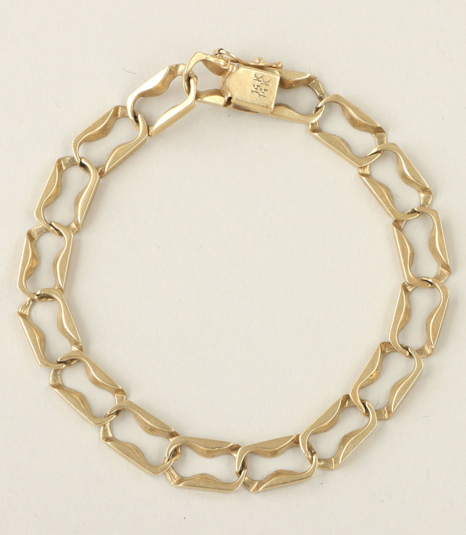14k gold curb chain bracelet: 14k gold curb chain bracelet, having large, shaped links with openings in the form of S-curves, Israel, marked on clasp. Minor wear. 8-1/2''l (open); approximate weight 13.6 dwt.