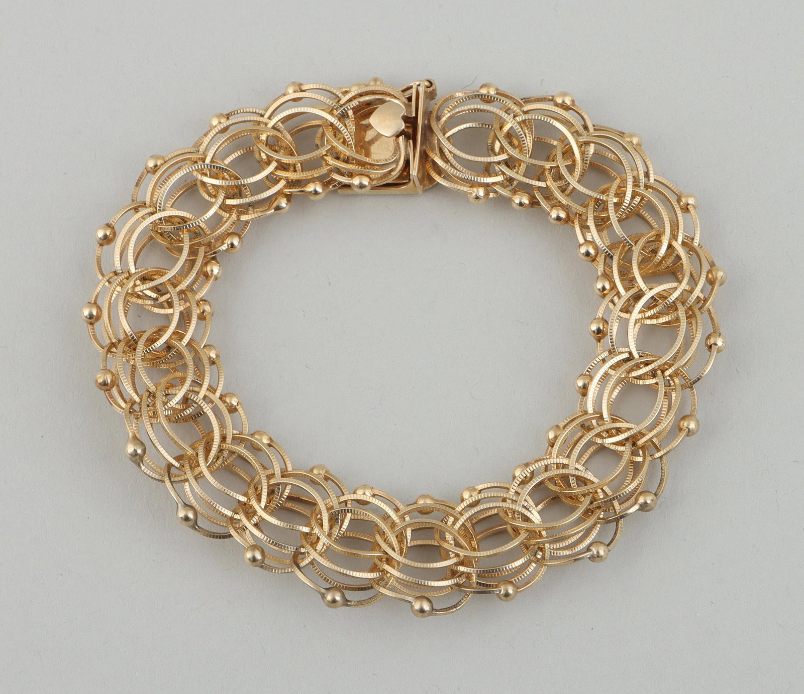14k gold parallel chain bracelet: 14k gold parallel chain bracelet having reeded triple-ring links with spheres at top and bottom, marked on clasp. Minor wear. 7-3/4''l (open); approximate weight 14.6 dwt. Provenance: Estate of Joseph