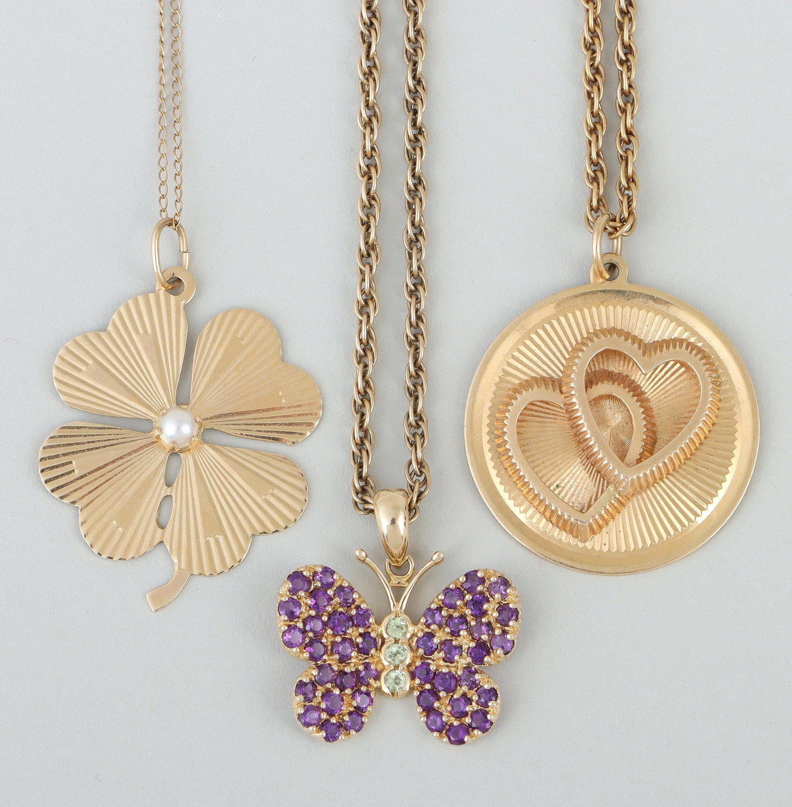 Group of (3) 14k gold pendant necklaces: Group of (3) 14k gold pendant necklaces, to include: (2) rope chain necklaces, one having butterfly pendant pave-set with semi-precious stones, the other having a round pendant with a pair of hearts i