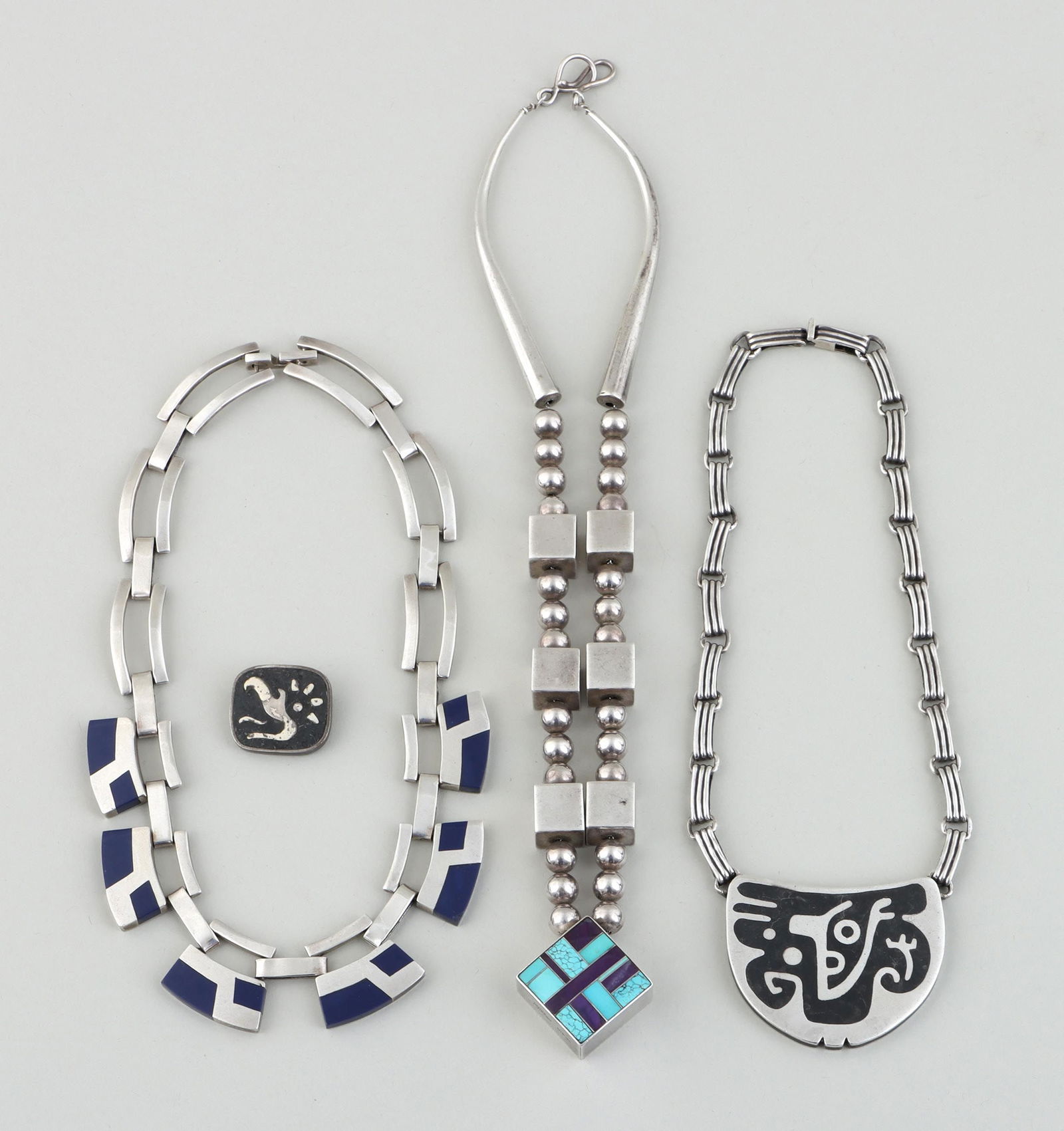Mexican and Native American sterling silver: Group of (4) Mexican and Native American sterling silver Modern jewelry with geometric designs, to include: RAY TRACEY (Dine, b. 1953), bead pendant necklace, the square pendant having a mosaic with i