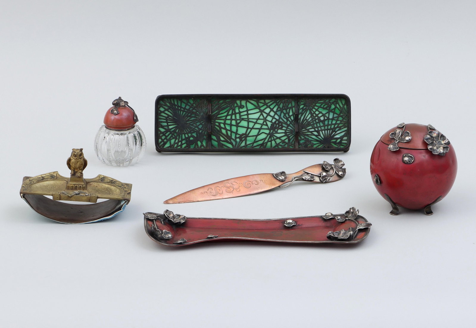 Group of (6) desk accessories: Group of (6) desk accessories, to include: Tiffany Studios patinated bronze and slag glass pen tray in the ''Pine Needle'' pattern, (glass with crack); Austrian bronze ink blotter, having owl on a ped