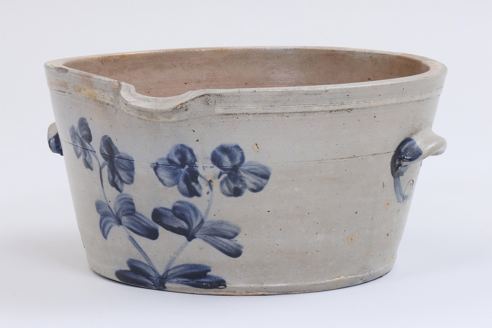 19th century 2-gallon milk pan: 19th century American stoneware 2-gallon milk pan with cobalt flower design, incised line decoration and applied lug handles, impressed gallon mark. Chips to rim. 6-1/2''h, 14''w, 13''d.