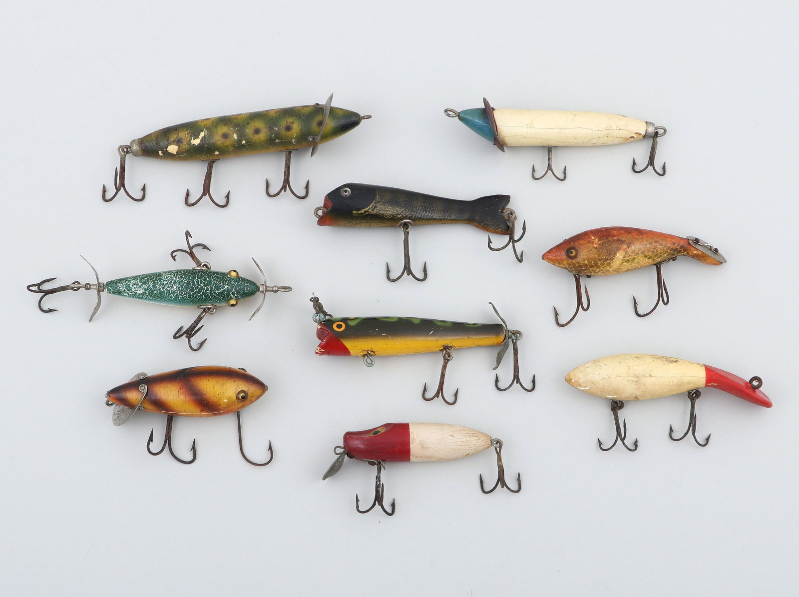 Group of (9) vintage wooden fishing lures: Group of (9) vintage wooden fishing lures, including: Heddon slopenose export, number 100; Heddon Dowagiac minnow, (2) Heddon crab wigglers; Heddon Expert; Rush-Tango, and others. All in as-found cond