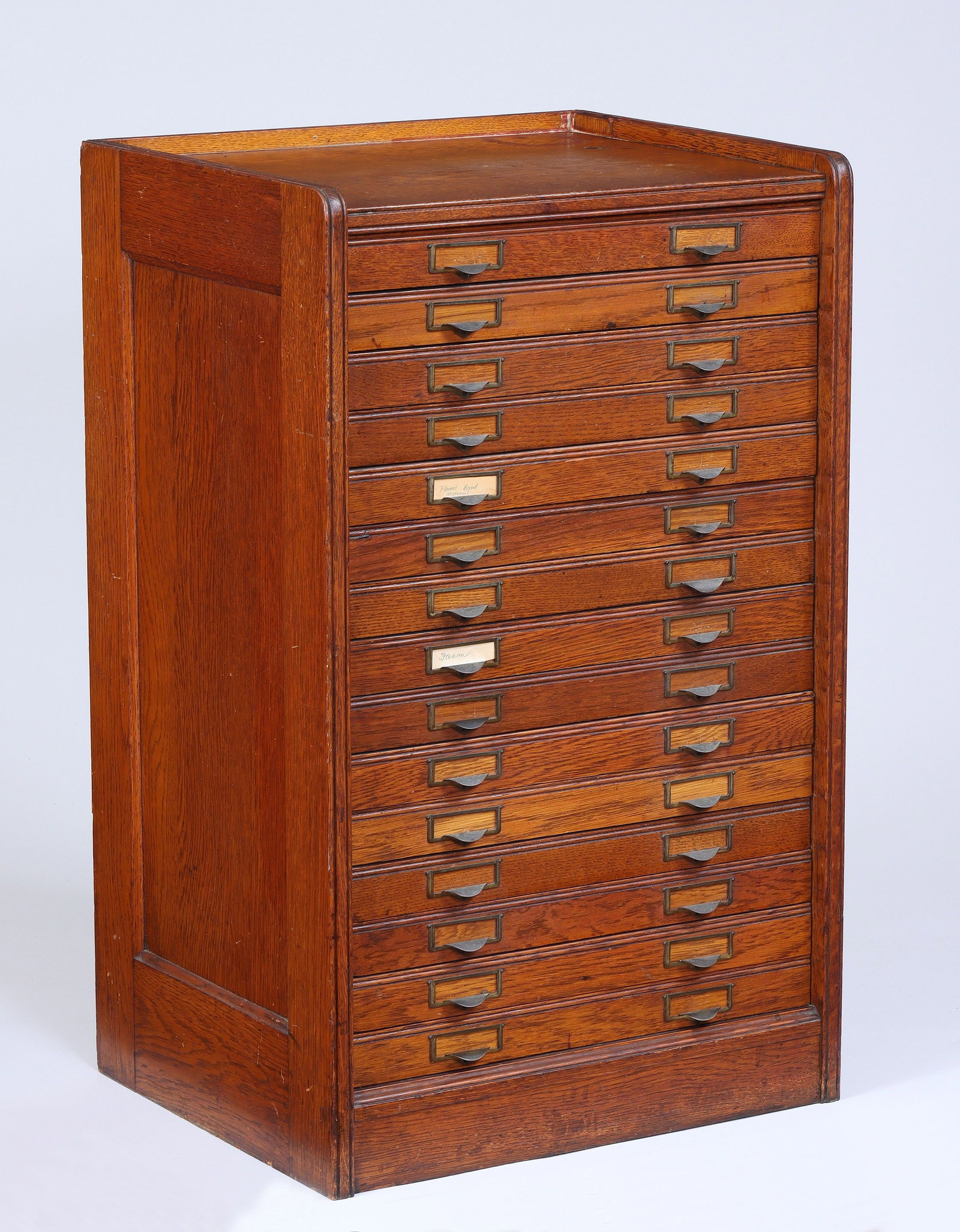 Small fifteen-drawer oak flat file cabinet: Small fifteen-drawer oak flat file cabinet with brass label slots, early 20th century. Some stains and wear to surface. 33''h, 20-1/2''w, 16-3/4''d.