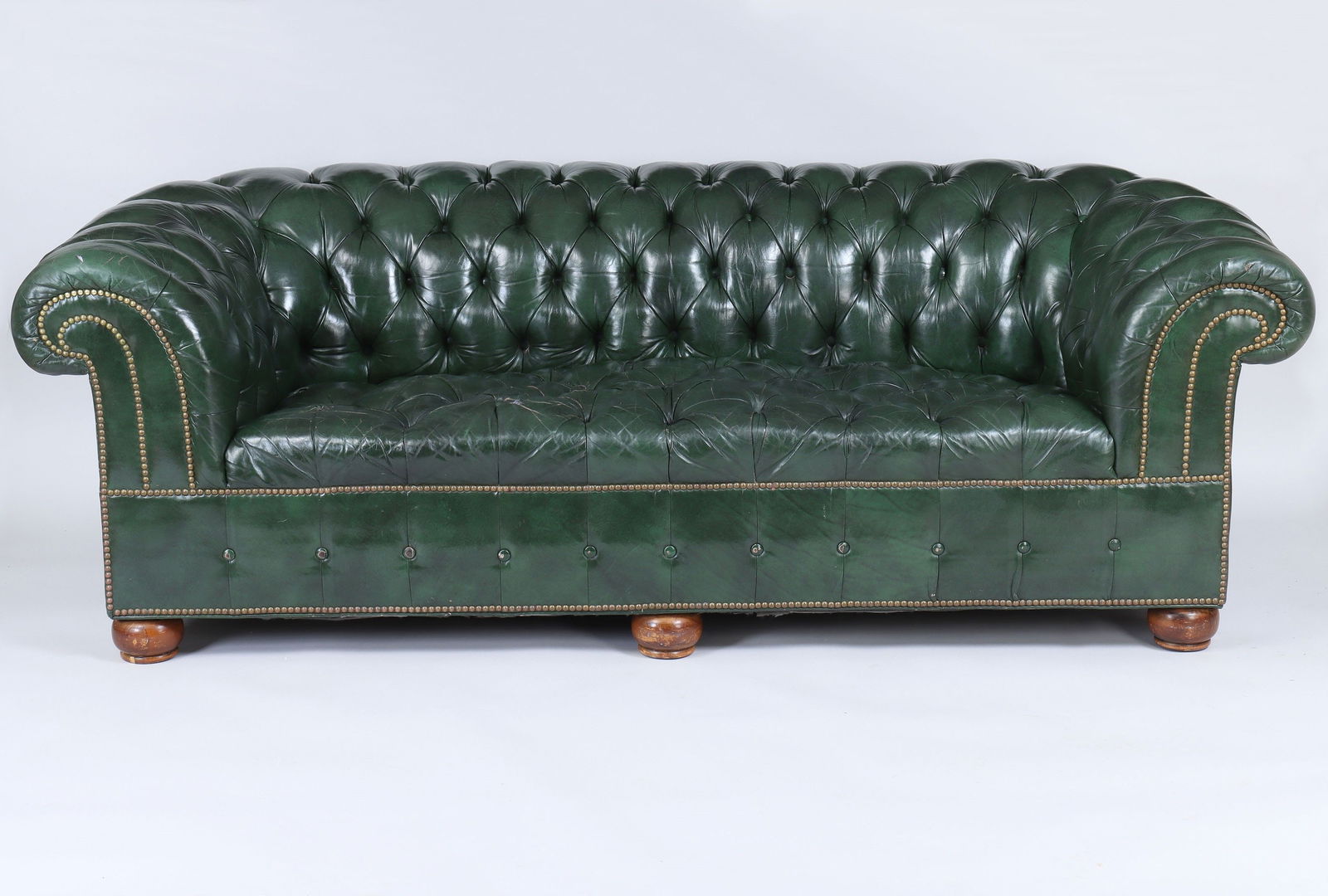 Green leather Chesterfield sofa: Green leather Chesterfield sofa. Tears, popped buttons. 26''h, 86''w, 37-1/2''d.