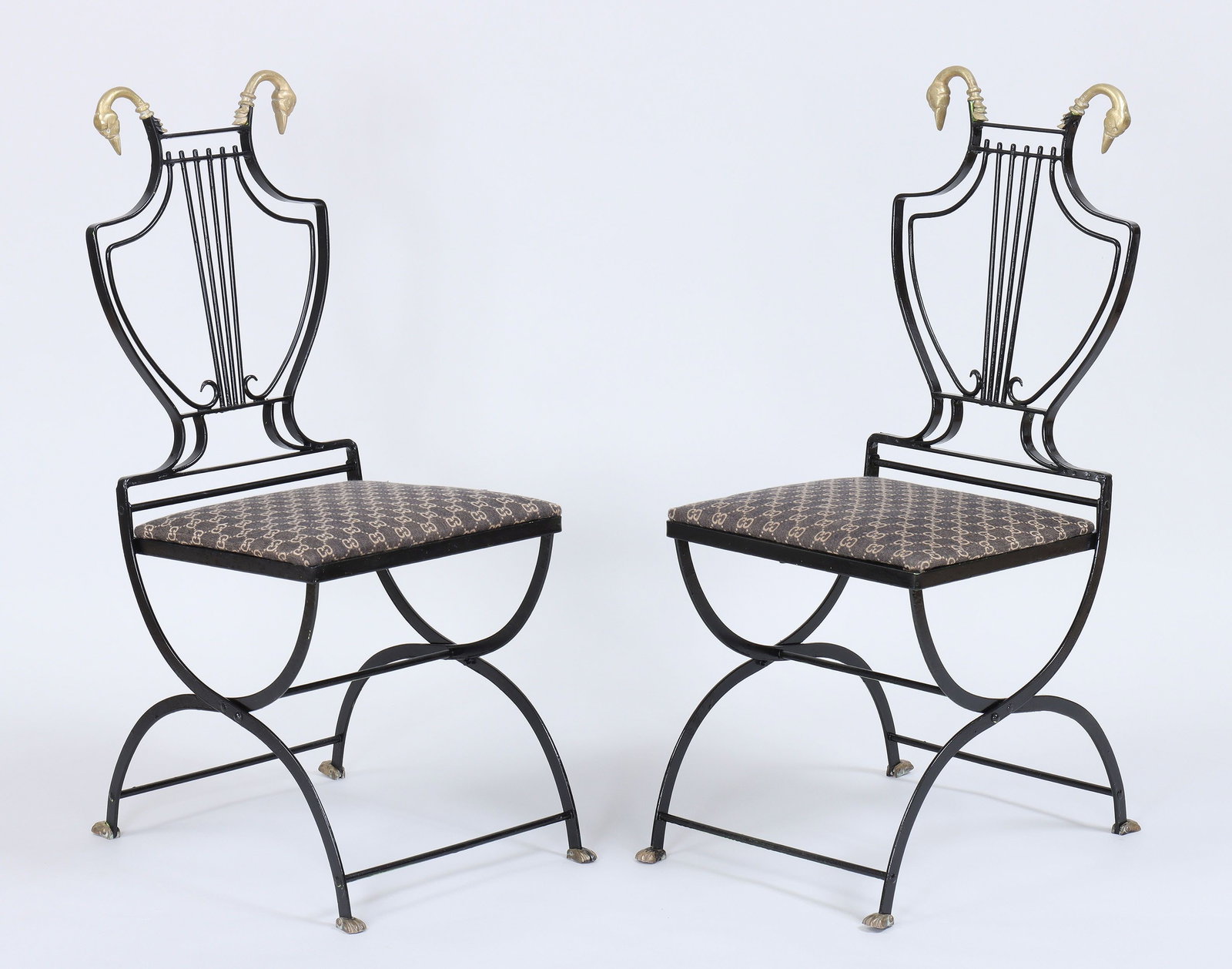 Pair of folding lyre-back swan chairs: Pair of Maison Jansen-style folding lyre-back swan chairs, black-painted wrought iron with gilt brass swan heads and curule legs ending in gilt brass paw feet. Repainted. 35-3/4''h, 20''w, 15''d.