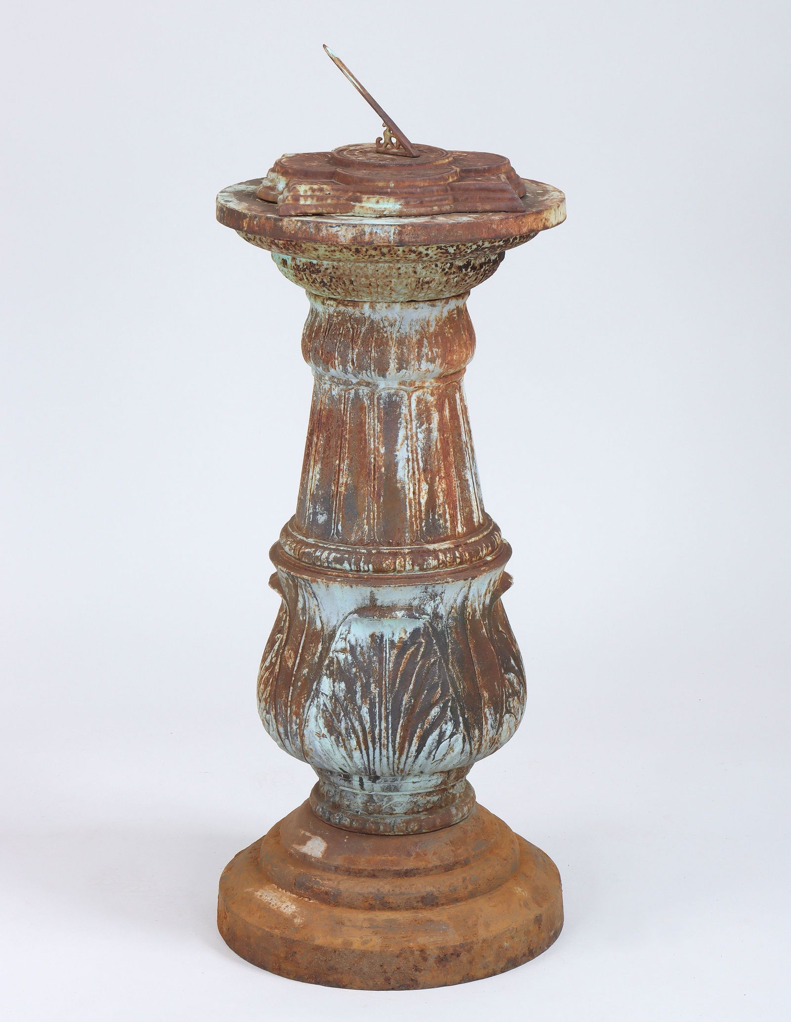 Cast iron sundial: Cast iron sundial, having round columnar base with palmette relief decoration and quatrefoil dial with foliate relief design. Rust, dial not attached. 40''h including dial.