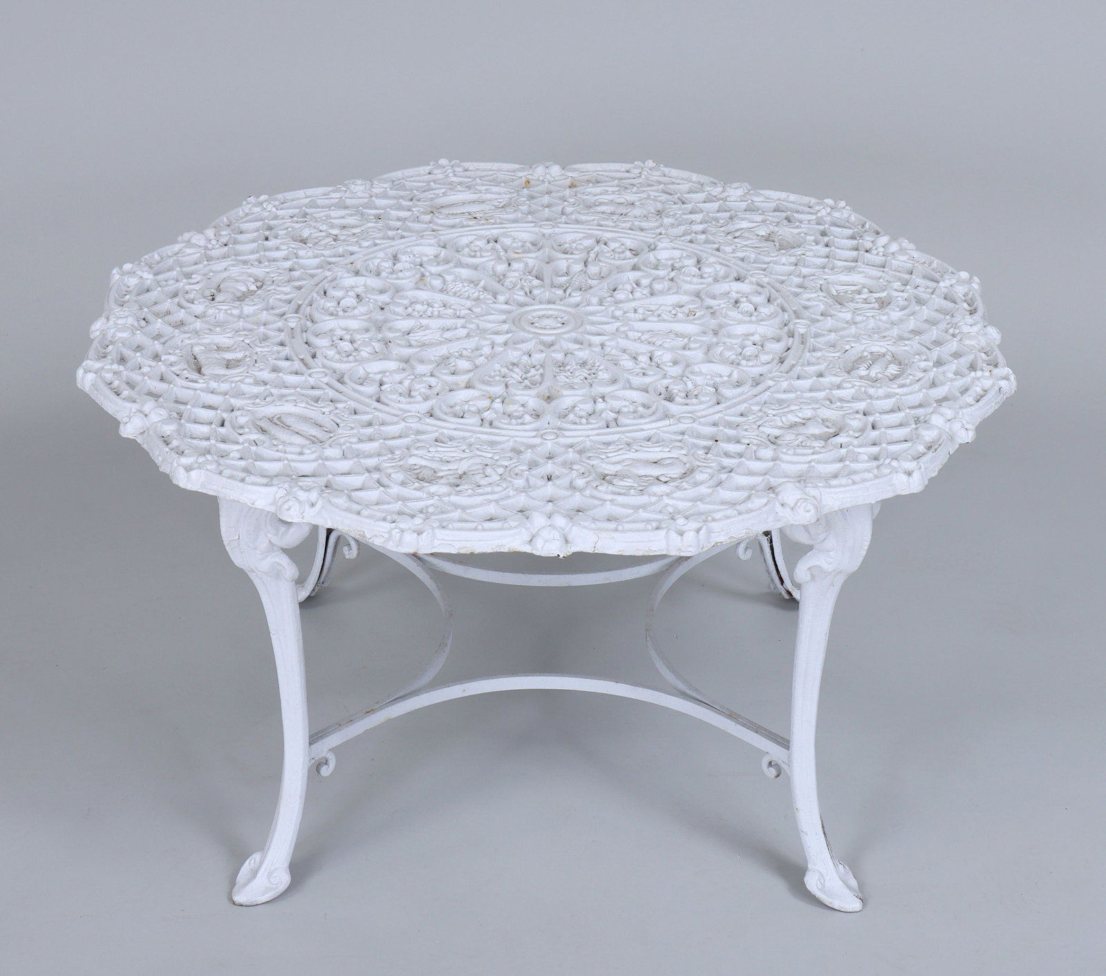 Cast iron zodiac garden table: Cast iron zodiac garden table, having pierced circular top with scalloped rim decorated with fruit and flower festoons, and a latticework border with cartouches enclosing symbolic depictions of the tw