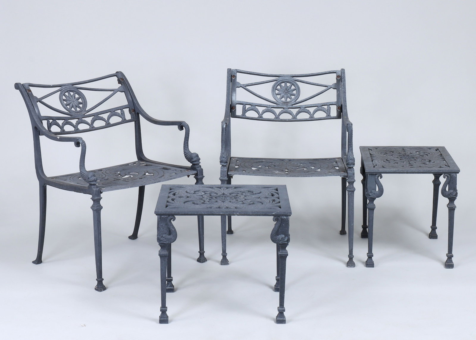 Neoclassical-style cast aluminum patio set: Four-piece Neoclassical-style cast aluminum patio set with star and dolphin decoration, to include a pair of armchairs, and two side tables. Armchair 30''h, 22''w, 22''d.