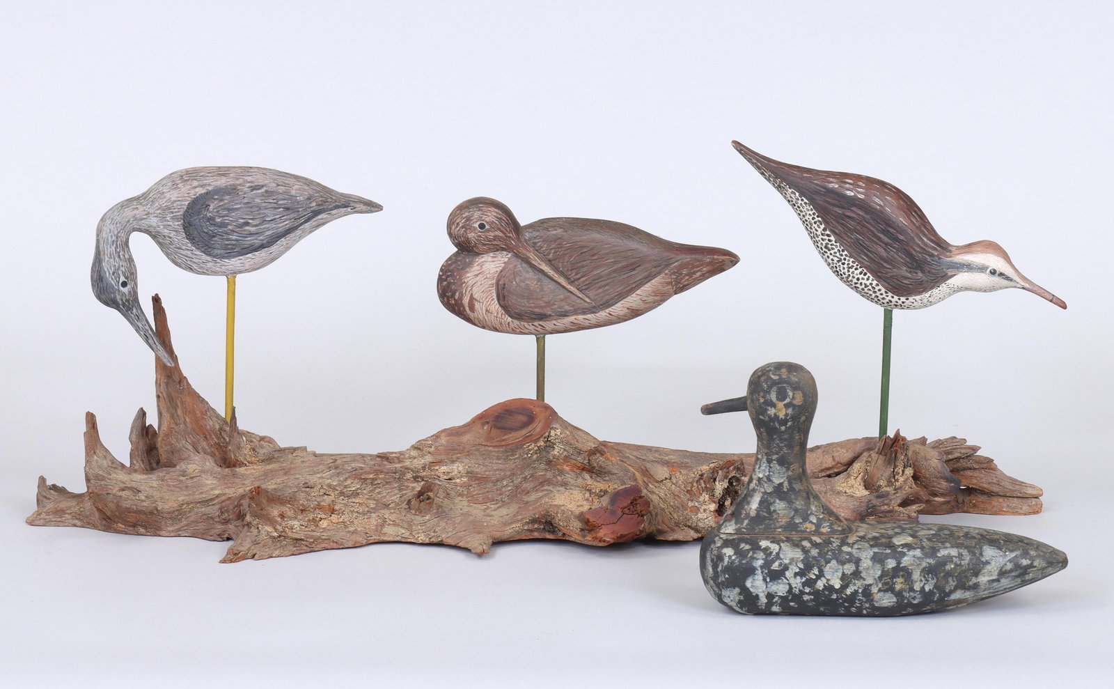 Group of (4) Decoys: Group of (4) Decoys to include: (3) folky shorebird silhouettes by Daniel S. Stacey, having one side carved in relief, mounted together on a driftwood base; along with a folky black-bellied plover, ha