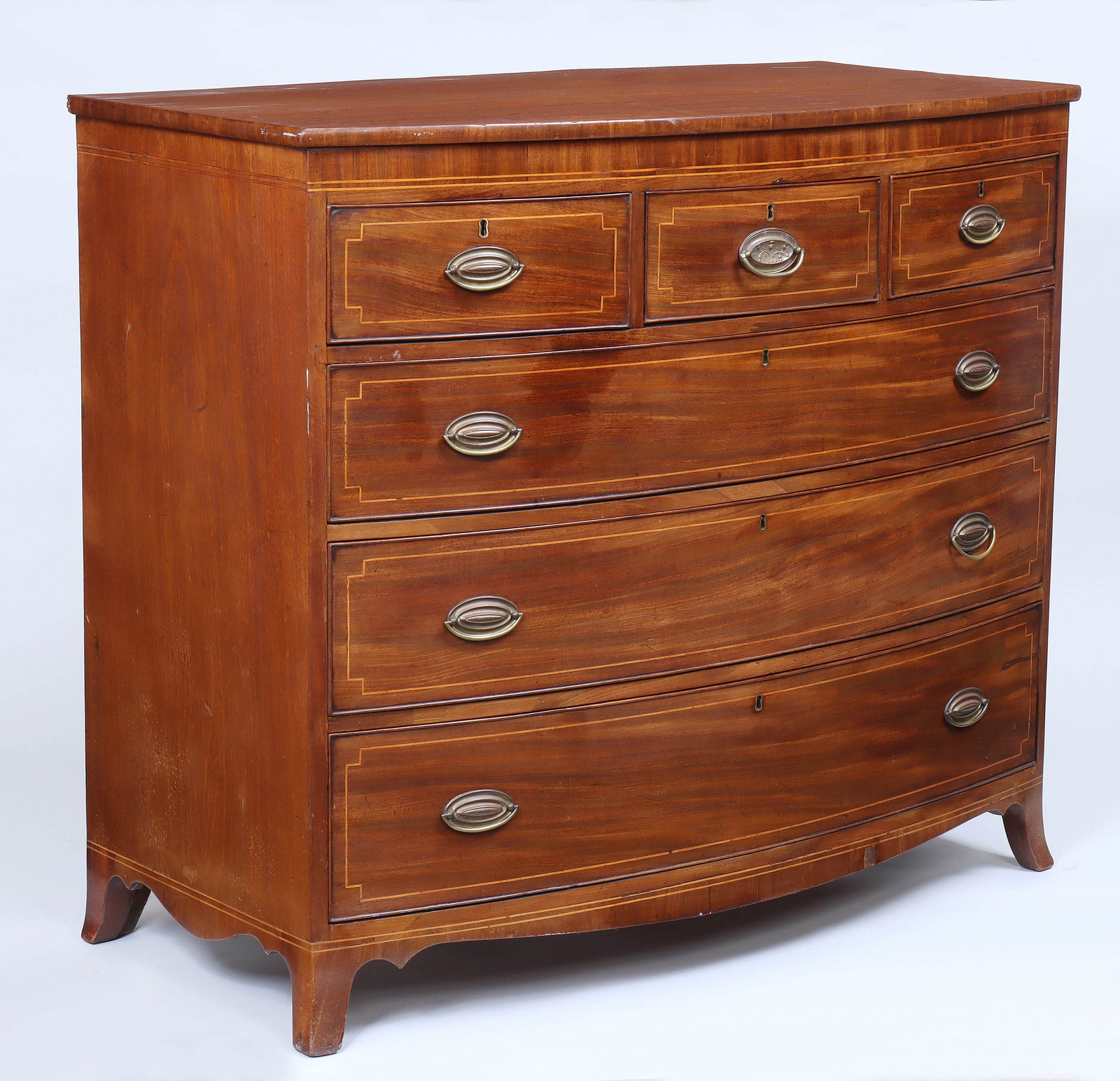 19th Century Bowfront Six-Drawer Chest: 19th Century Bowfront Six-Drawer Chest having three short drawers over three graduated long drawers, with line inlay decoration, on bracket base. 41 1/2 x 48 x 23 1/4 in. (105.4 x 121.9 x 59.1 cm.)