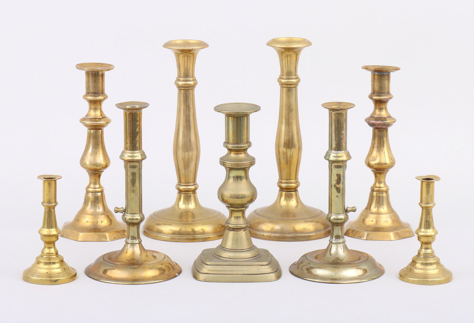 Group (9) Brass Candlesticks, some English, 18th/19th century: Group of (9) Brass Candlestickssome English, 18th/19th century, to include: push-up pair; miniature pair with push-up mechanism inside bases, one numbered “2” on mechanism, the other “6&rdqu