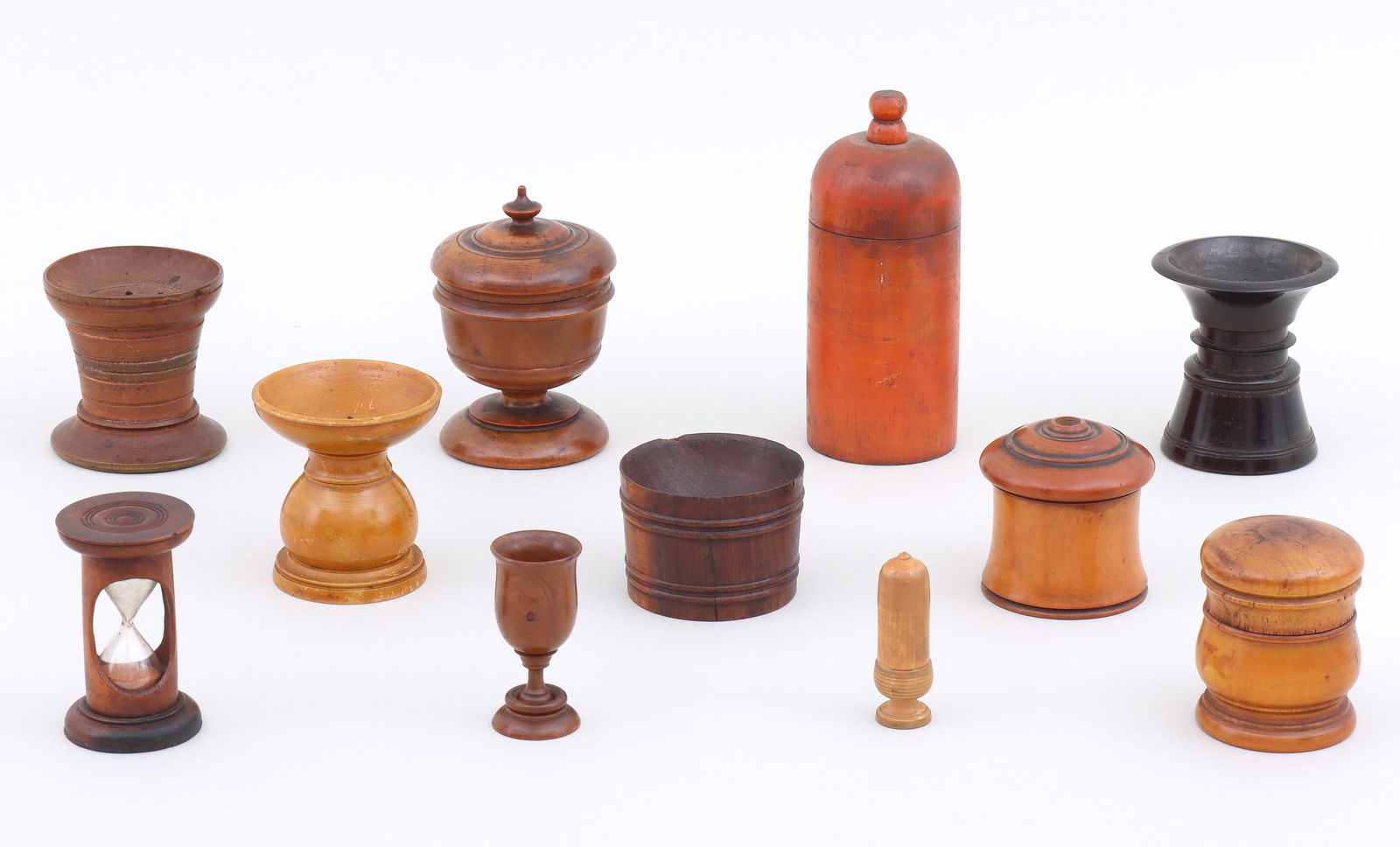 Group of (11) Treen and Turned Wood Items: Group of (11) Treen and Turned Wood Itemsto include: (3) sanders or pounce pots; hourglass timer; bucket-form vessel; jar with screw-on lid; covered matchbox with strike plate on bottom; covered tooth