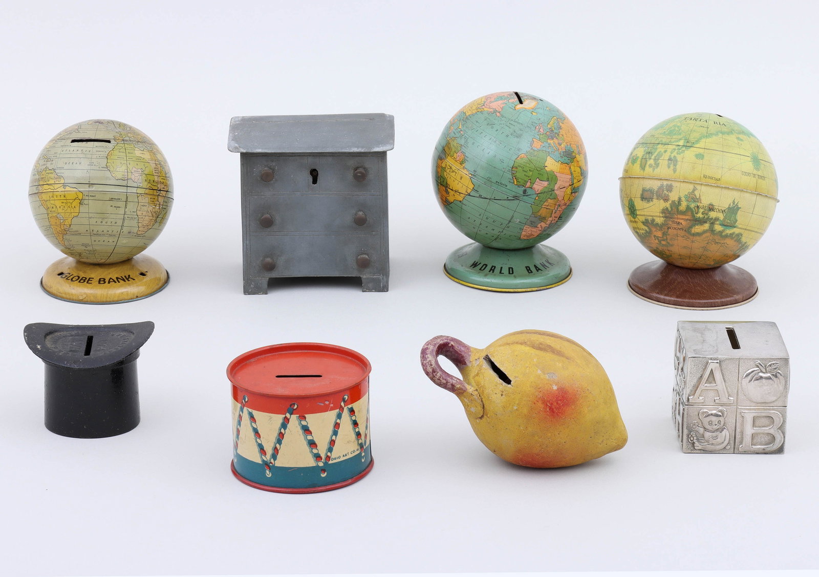 Collection of (8) Still Banks: Collection of (8) Still Banks to include: top hat bank, black-painted cast iron, embossed “Pass Around the Hat”; steel chest of drawers bank, probably English, 19th century; Mexican clay fruit