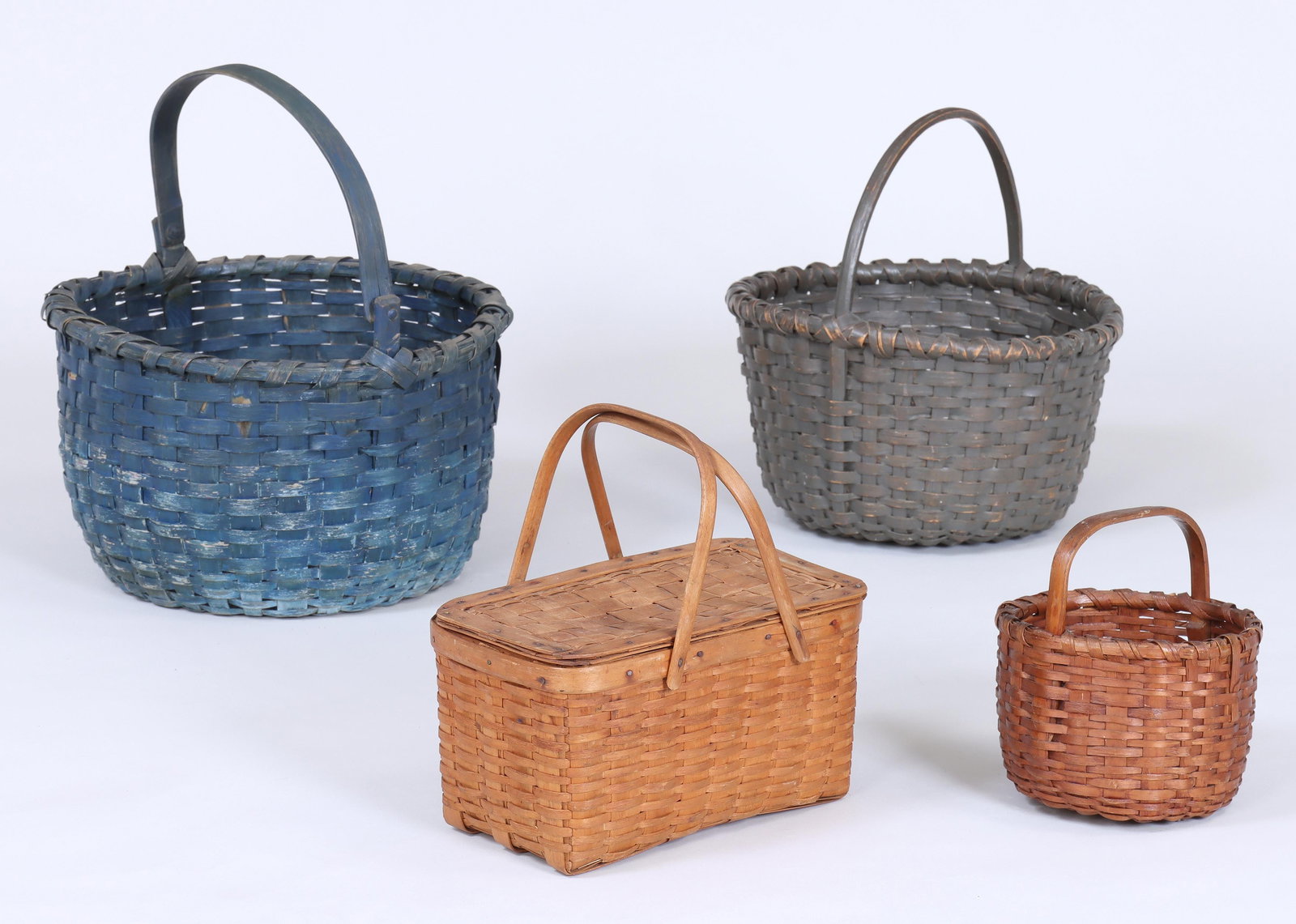 Group of (4) American Splint Baskets: Group of (4) American Splint Baskets to include: rectangular picnic basket having cover with leather hinges and pair of swing handles, possibly Maine, (minor dirt and grime); blue-painted basket with 