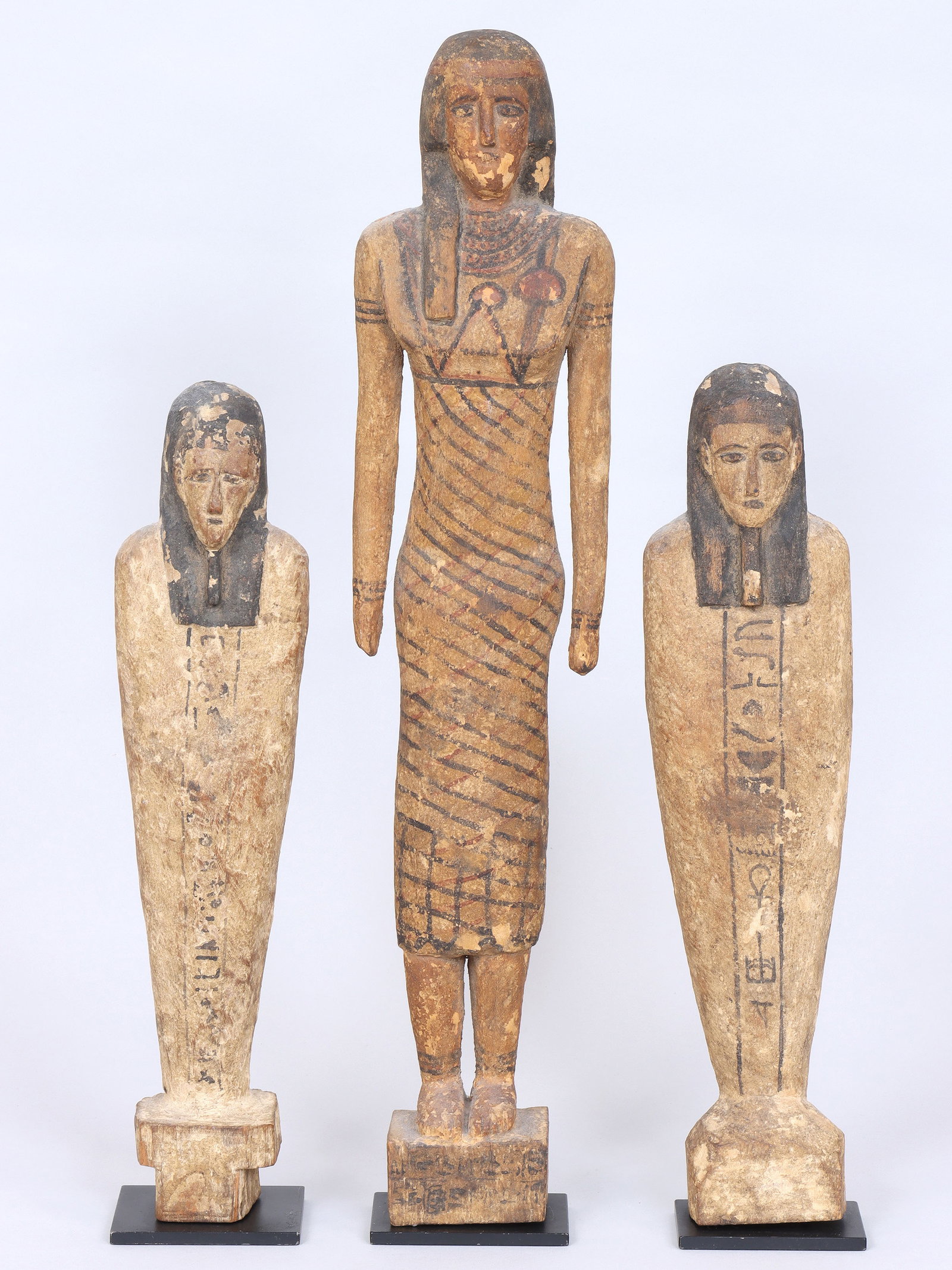 Group of (3) Ancient Egyptian Carved Wood Figures: Group of (3) Ancient Egyptian Carved Wood Figures to include: figure of woman, with hieroglyphics on back and two sides of base; and (2) ushabti, with hieroglyphics on front and back. All mounted on m