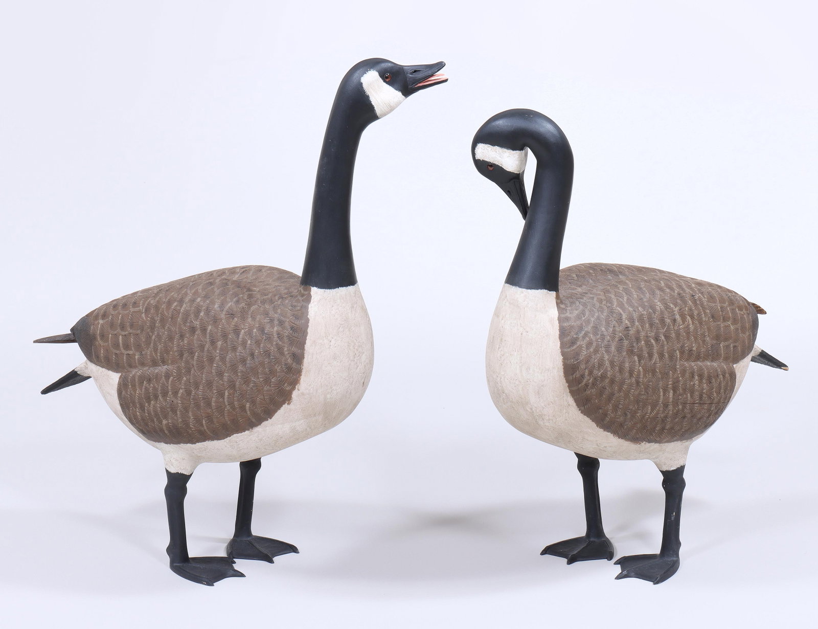 Pair of Life-Size Folk Art Carved and Painted Canada Geese: Pair of Life-Size Folk Art Carved and Painted Canada Geese probably by Dominique Viennotte, New Brunswick, Canada, 20th century, impressed "Dominique" mark to underside with maple leaf in a 