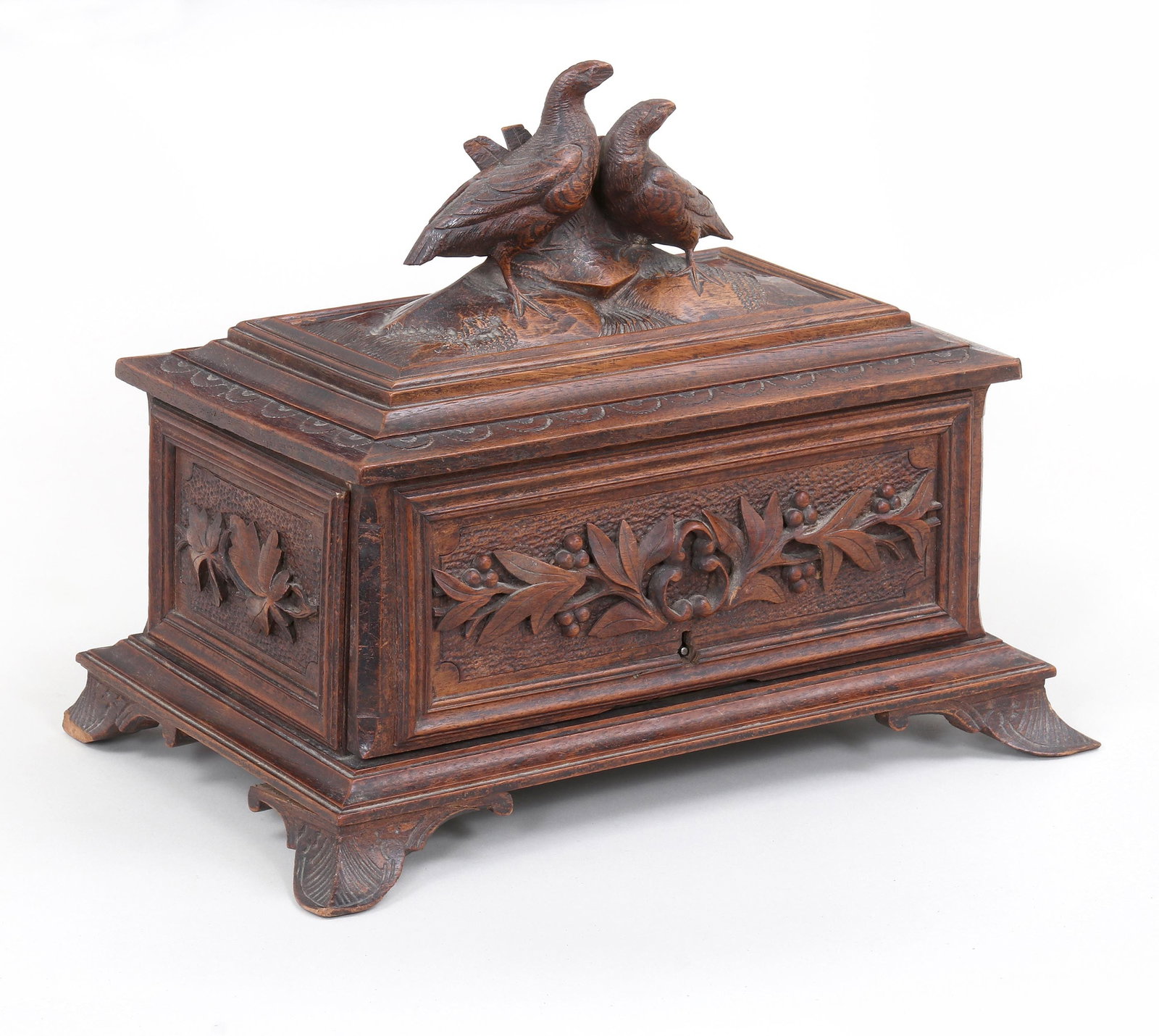 Black Forest Carved Humidor: Black Forest Carved Humidor having hinged lid with pair of partridges on top, front with leaf and berry design in relief, and sides with foliate design in relief, all on foliate feet. 9 1/8 x 11 3/4 x