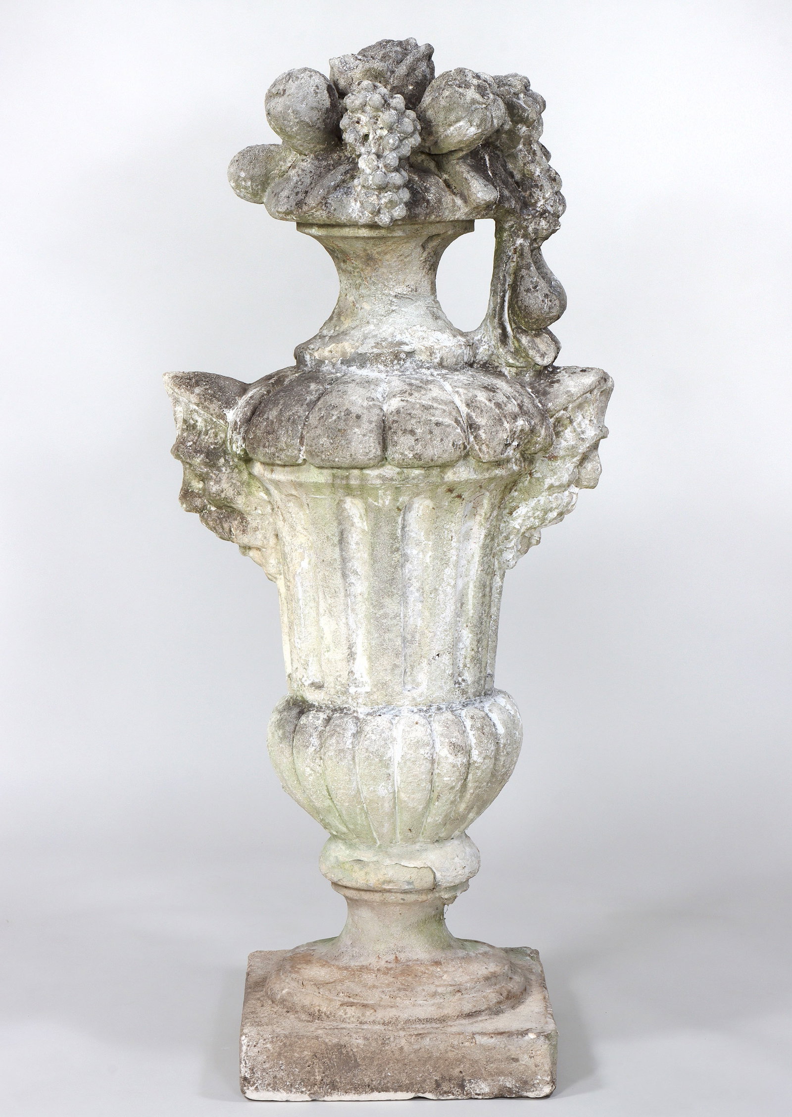 Large 18th/19th Century Carved Limestone Urn: Large 18th/19th Century Carved Limestone Urn having fruit basket set on a footed urn with fluted and lobed body flanked by Northwind mask handles. 54 1/2"h x 24"w x18 1/2"d