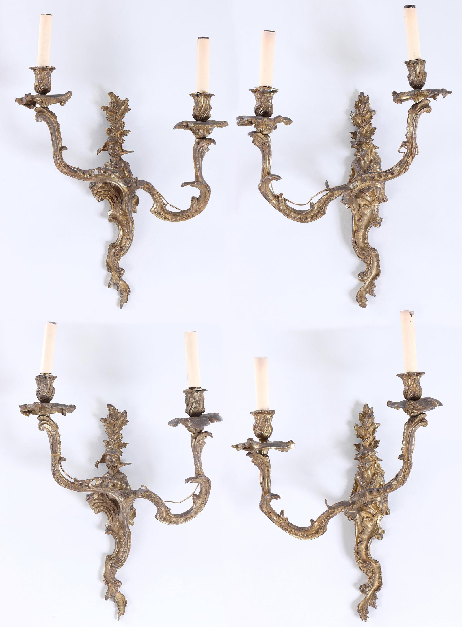 Set of (4) Louis XV Chinoiserie Gilt Bronze Two-Light Sconces: Set of (4) Louis XV Chinoiserie Gilt Bronze Two-Light Sconces having figural backplates with scrolled foliate design supporting a pair of rocaille scroll arms, two sconces with male figures, the other