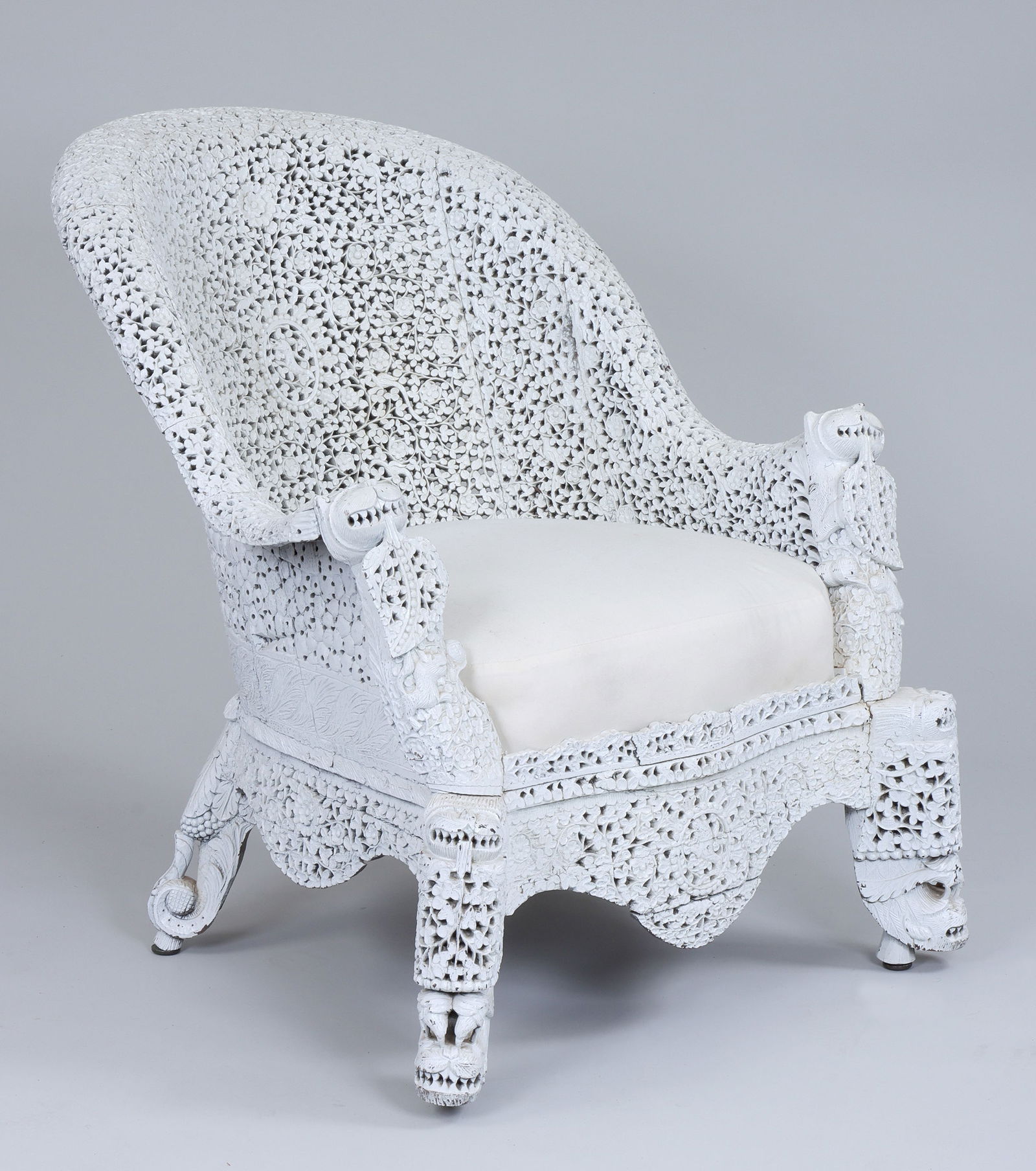 Burmese Carved Barrel-Back Armchair: Burmese Carved Barrel-Back Armchairwith pierced foliate decoration and beast-form armrests and front legs, in white paint.35-1/4"h x 31"w x 39"d