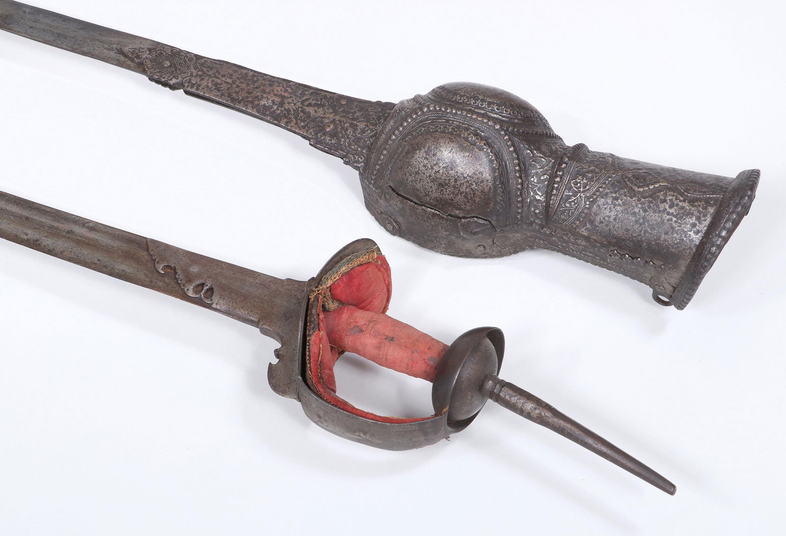 Group of (2) Indian Swords: Group of (2) Indian Swordsto include: firangi, with fabric padding on grip, (fabric with fraying at edges and stains); and pata, having gauntlet or arm guard with scrolled foliate design and beaded bo