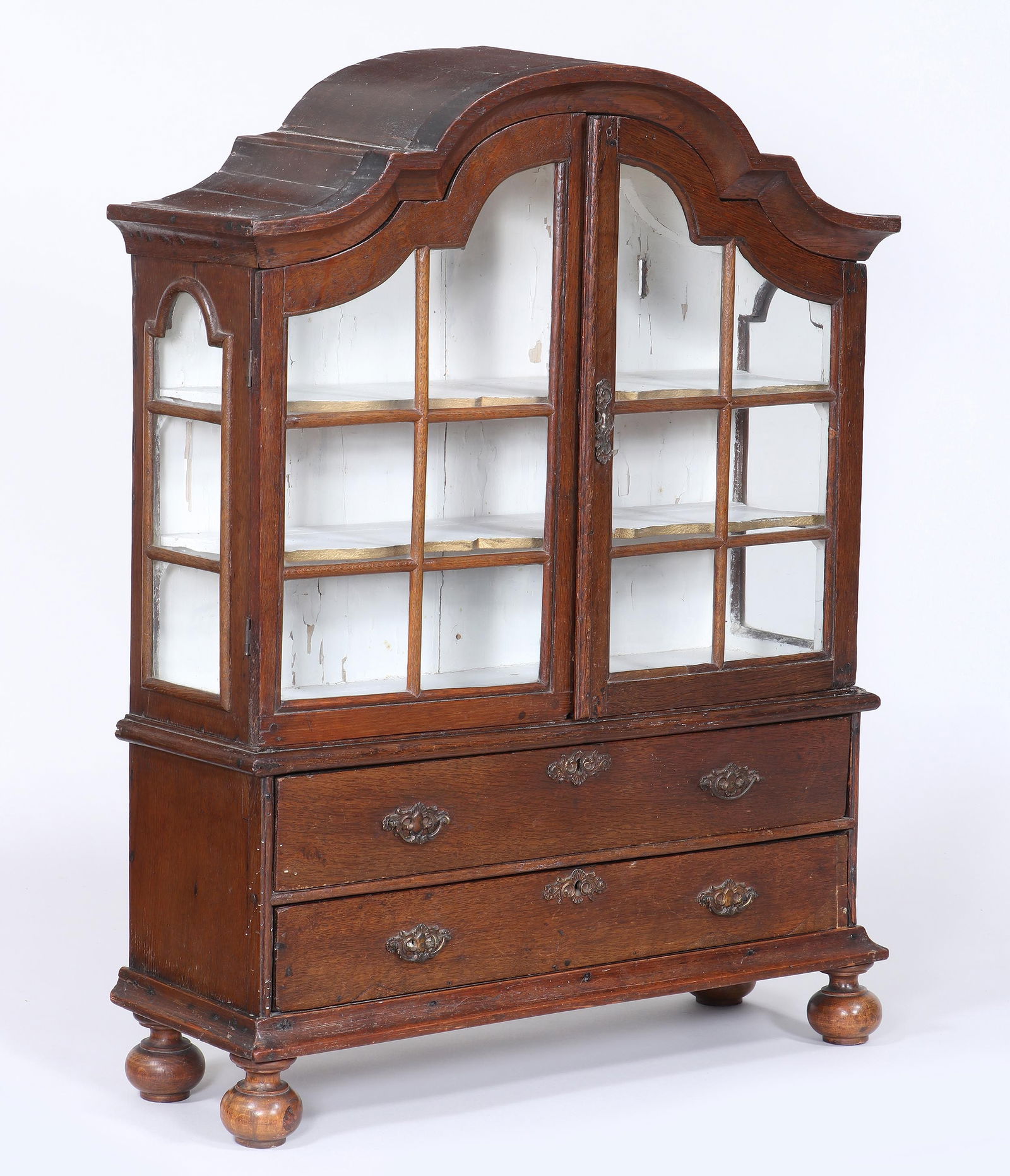 18th Century Dutch Miniature Oak Cabinet: 18th Century Dutch Miniature Oak Cabinethaving shaped pediment over two glazed doors opening to a shelved interior, above two long drawers, raised on bun feet.30 1/2 x 23 3/4 x 7 3/4 in. (77.5 x 60.3