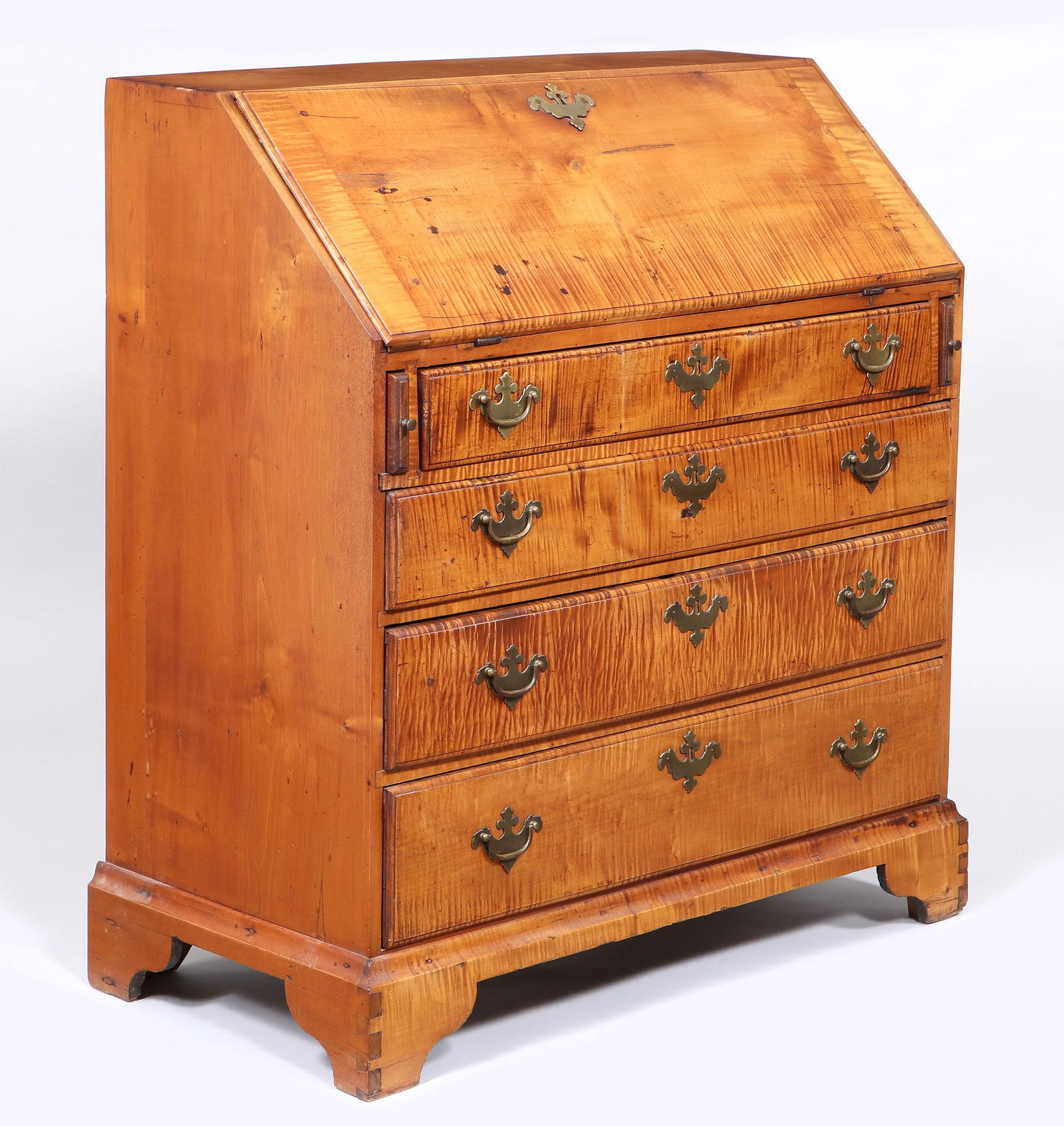 American Chippendale Tiger Maple Slant-Front Desk: American Chippendale Tiger Maple Slant-Front Deskthe front opening to a fitted interior with shell-carved central door flanked by turned pilasters and pigeonholes over four small drawers, above a case