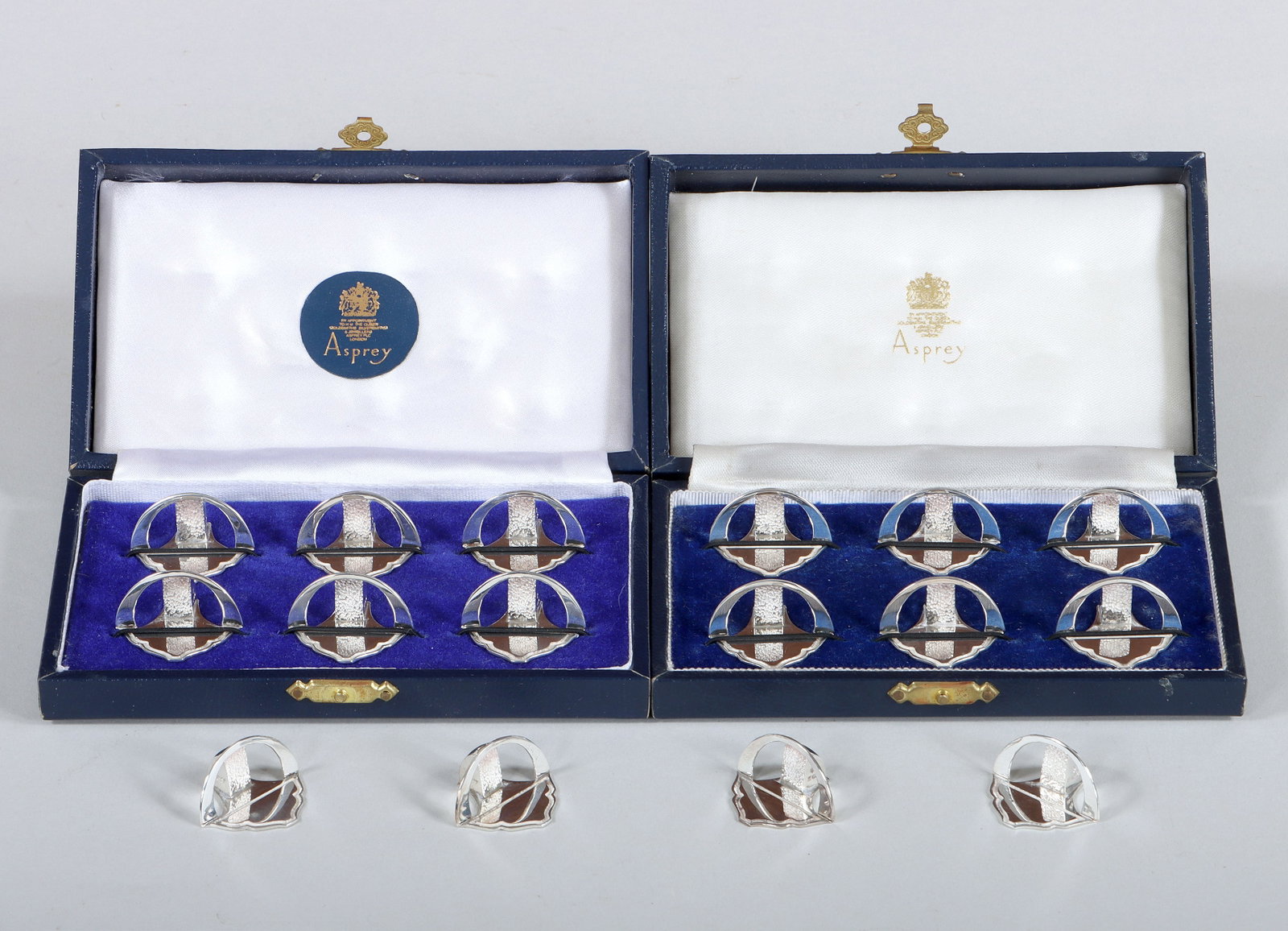 Asprey & Co. Sterling Silver Place Card Holders: Set of (16) English Sterling Silver Place Card Holders Asprey & Co., Birmingham, 1991 with shaped bases, hallmarked; along with (2) fitted cases. Width 1 in. (2.5 cm.); total approximate weight 4.6 tr