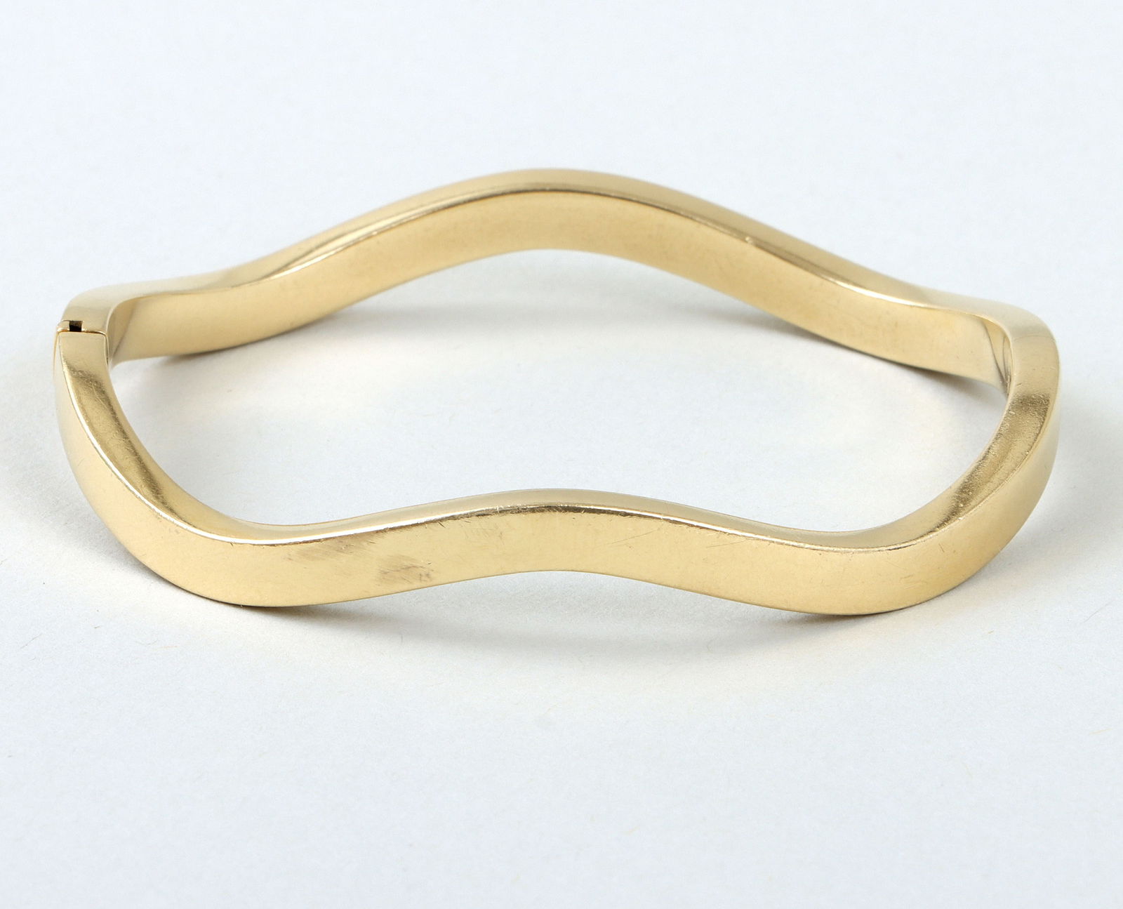 Tiffany & Co. 18k Gold Bangle: Tiffany & Co. 18k Gold Bangleof round, "wave" or undulating form, Italy, marked on clasp.Inner circumference 6 5/8 in. (16.8 cm.); approximate weight 10.2 dwt.