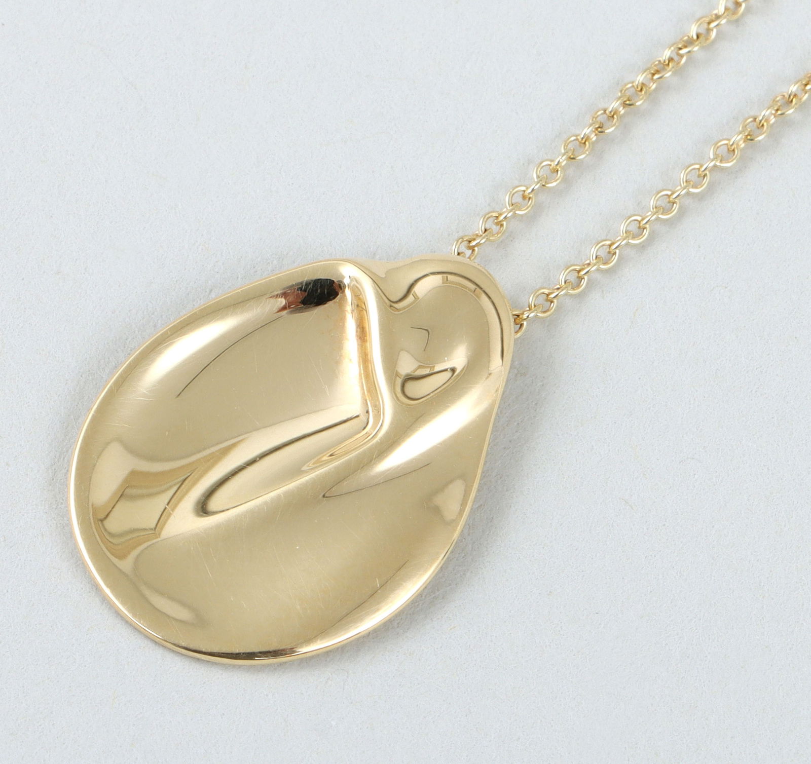 Elsa Peretti for Tiffany & Co. 18k Gold "Madonna" Necklace: Elsa Peretti for Tiffany & Co. 18k Gold "Madonna" Pendant Necklacefrom the Madonna collection, Spain, having a shaped pendant on a fine cable chain, marked and signed on back of pendant and clasp; alo